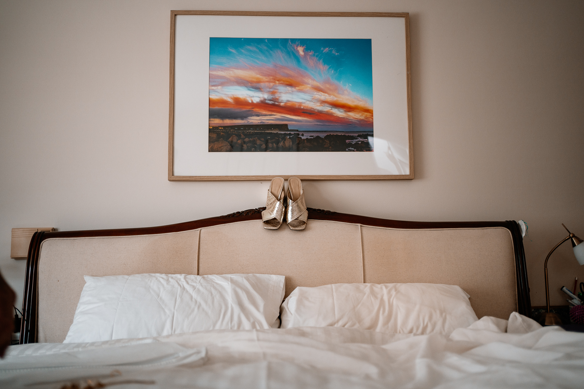 A bed with a painting on the wall