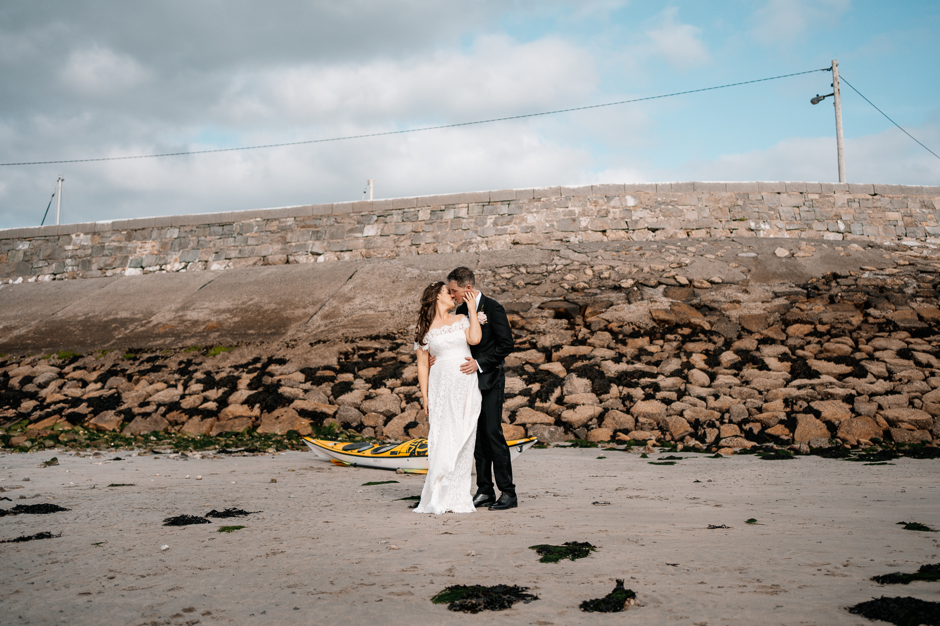 A man and woman kissing on a beach