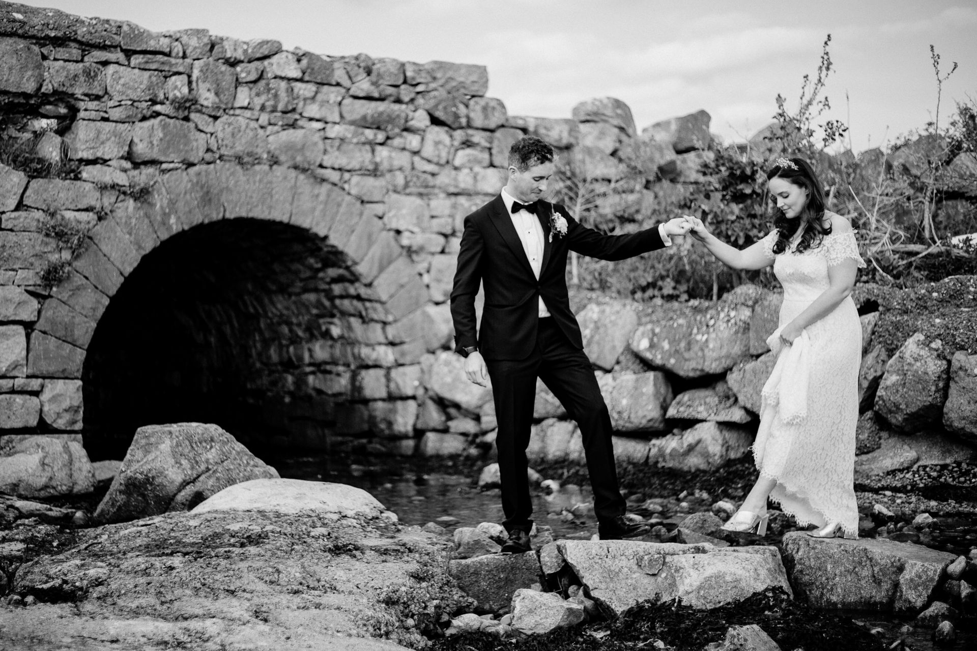 A man and woman posing for a picture in front of a stone archway