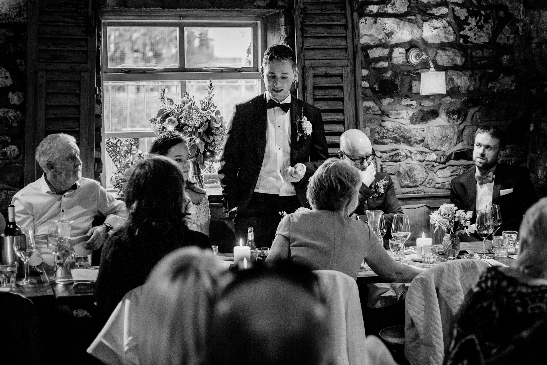 A person in a tuxedo talking to a group of people