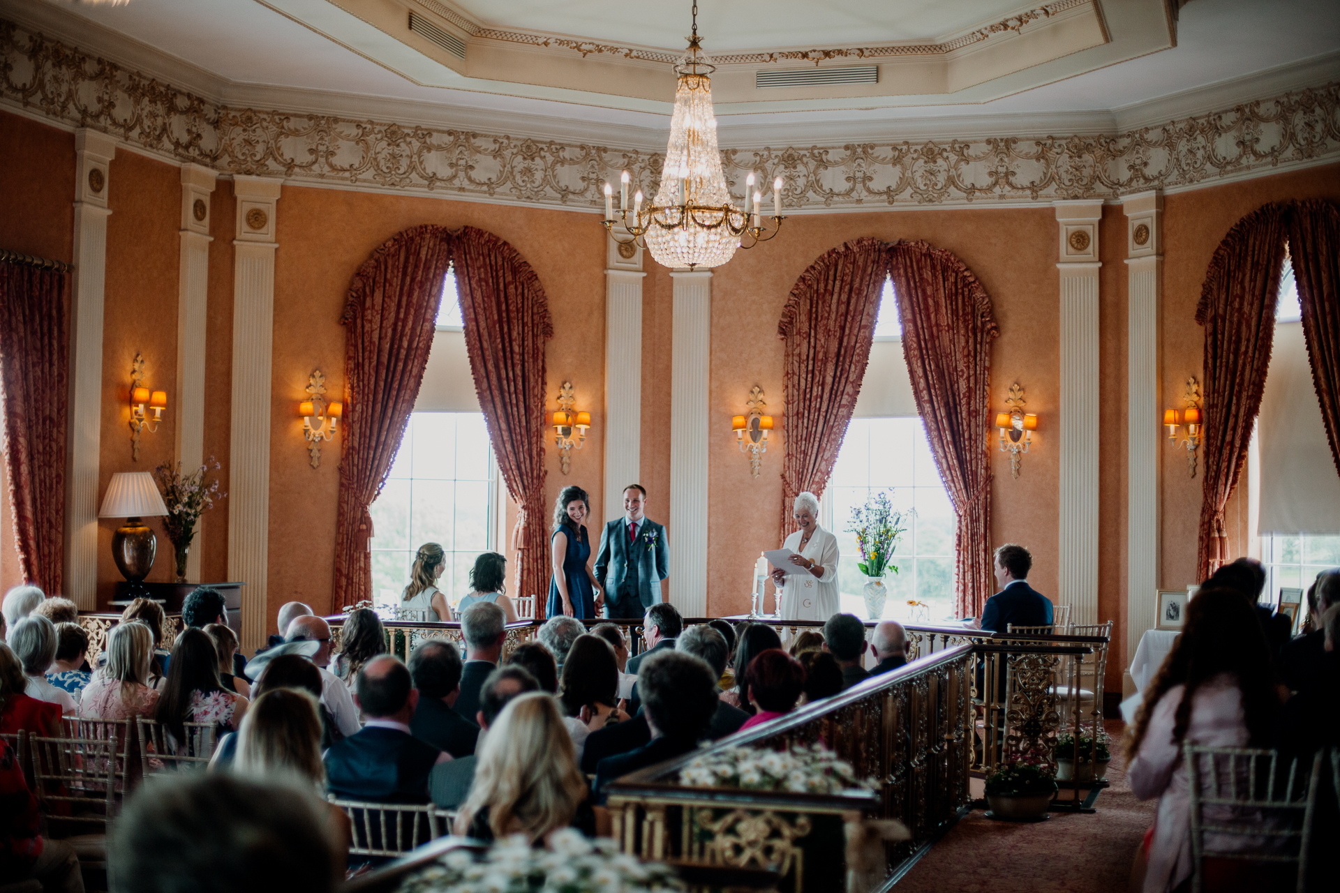 Bride and groom exchanging vows during their wedding ceremony at Glenlo Abbey Hotel, Galway.