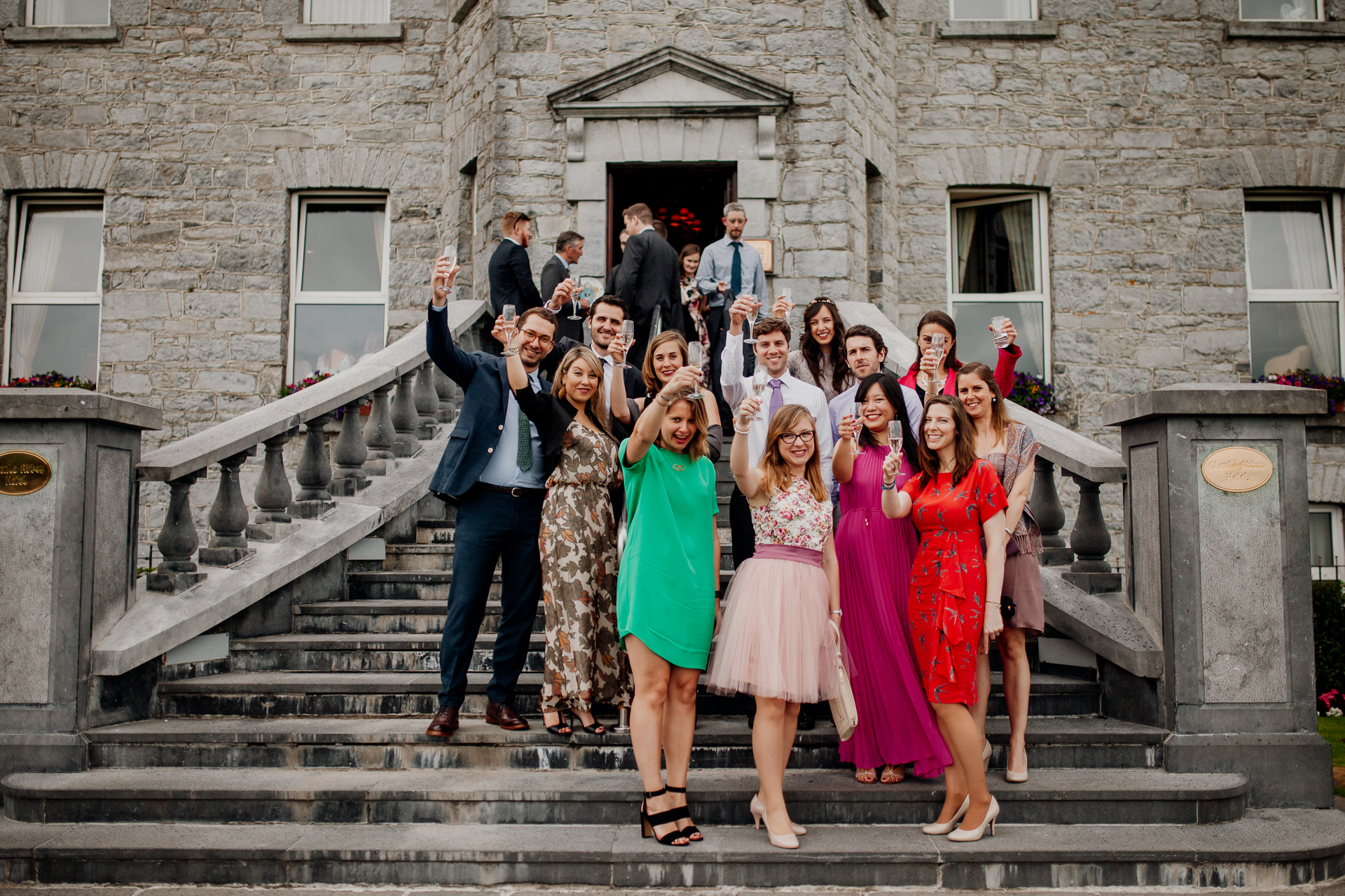 The bride and groom posing with their bridal party and family at Glenlo Abbey Hotel in Galway.