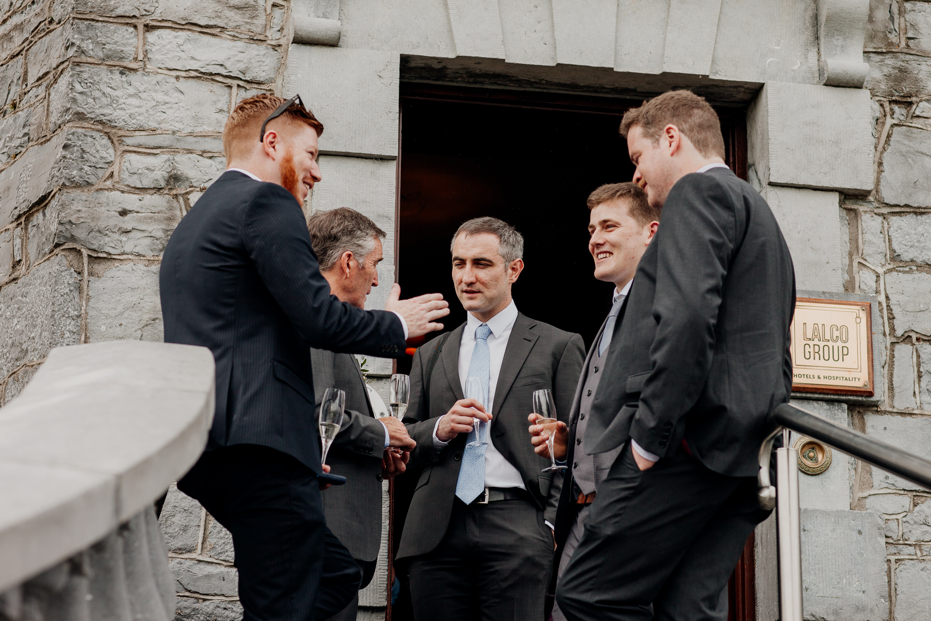 The bride and groom posing with their bridal party and family at Glenlo Abbey Hotel in Galway.