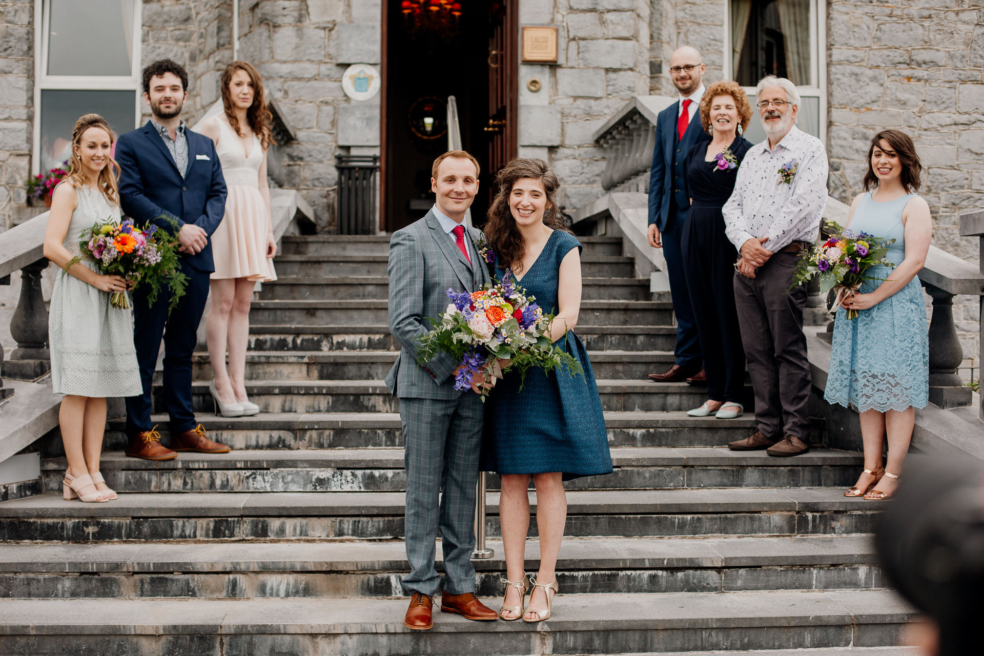 The bride and groom posing with their bridal party and family at Glenlo Abbey Hotel in Galway.