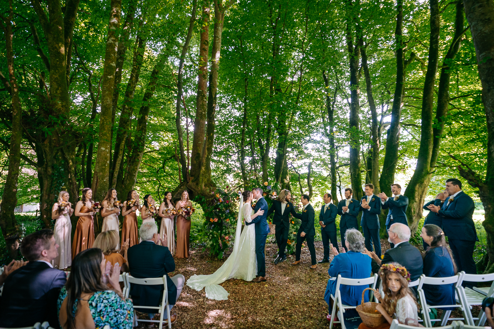 Outdoor forest wedding ceremony at Juniper Barn surrounded by trees and natural decor