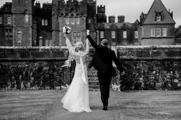 Bride and groom celebrating their wedding at Ashford Castle, Ireland – a joyful and timeless moment in front of the historic castle.