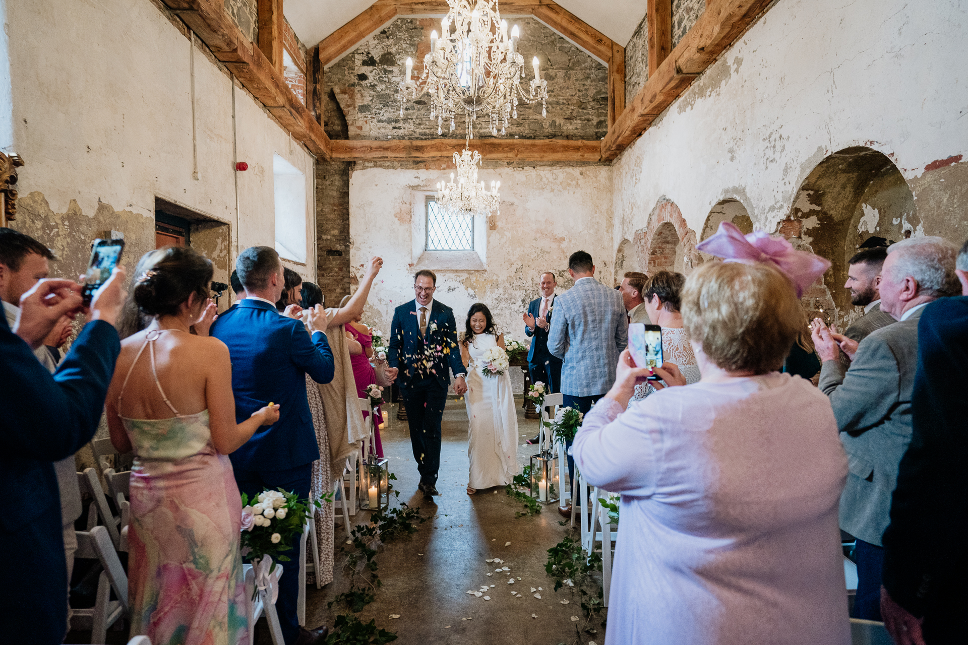 Bride and groom embracing in front of Belleek Castle, capturing a romantic wedding moment.