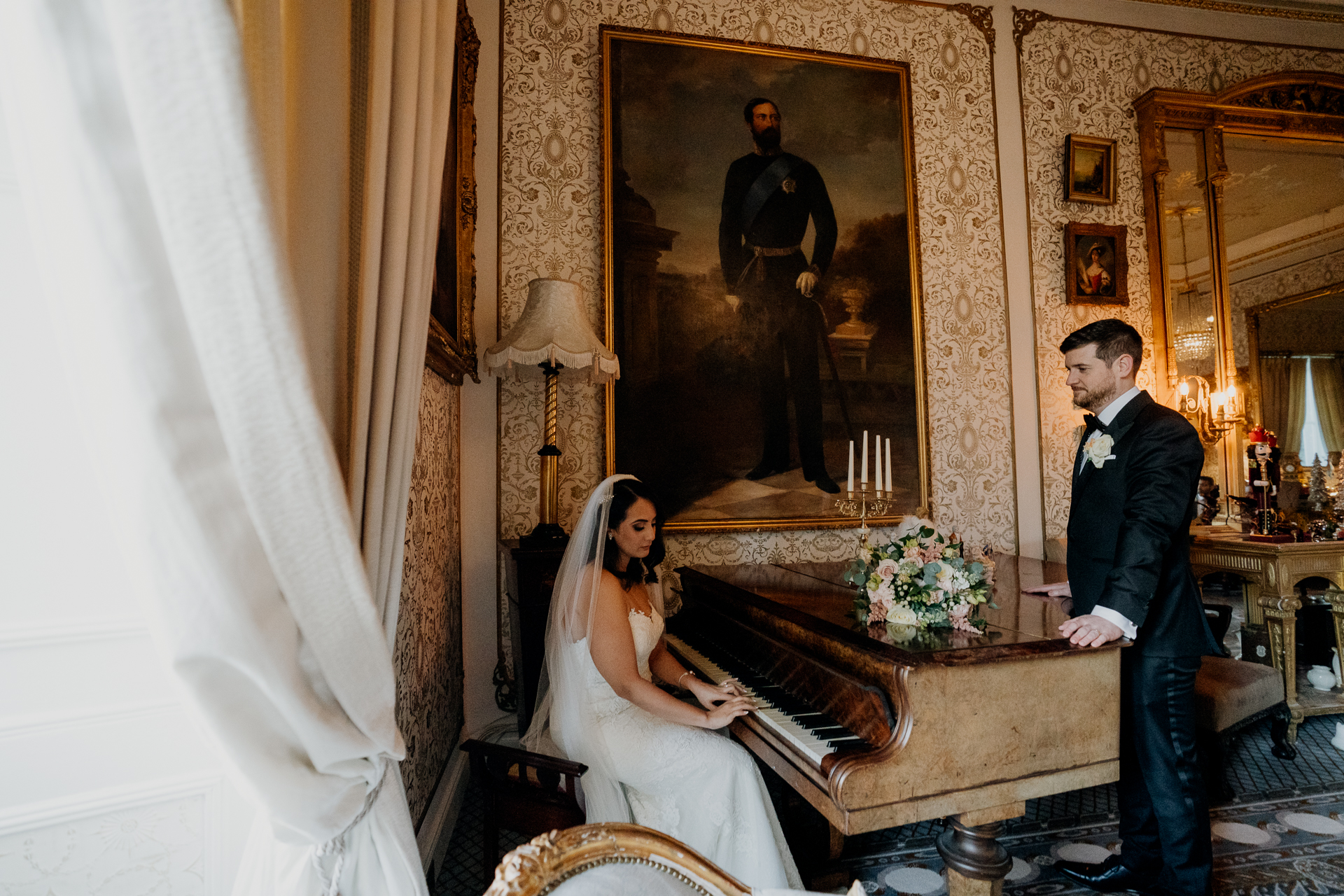 A bride elegantly seated at a grand piano in Cabra Castle, creating a timeless and artistic wedding moment.