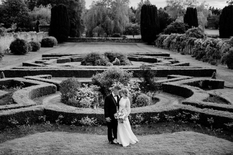 A newlywed couple in the elegant gardens of Kilkea Castle.
