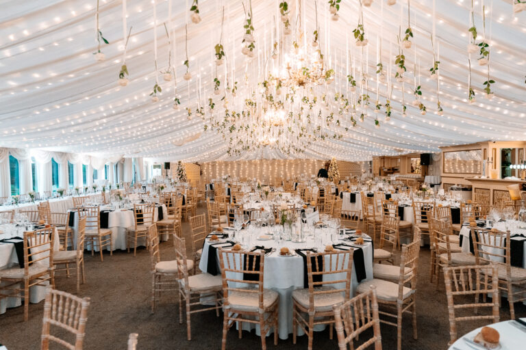Elegant wedding reception setup at Castle Leslie Estate with white drapery and greenery.