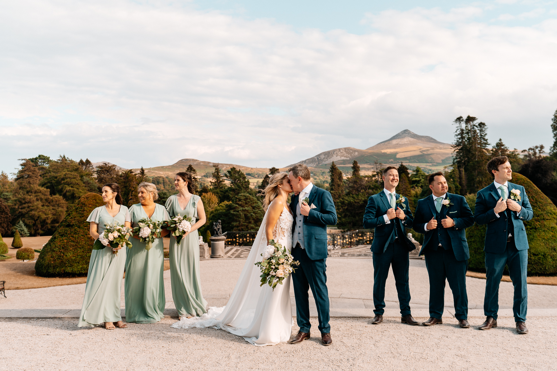 Bridal party celebrating outdoors with scenic Dublin mountains in the background – candid wedding photographer