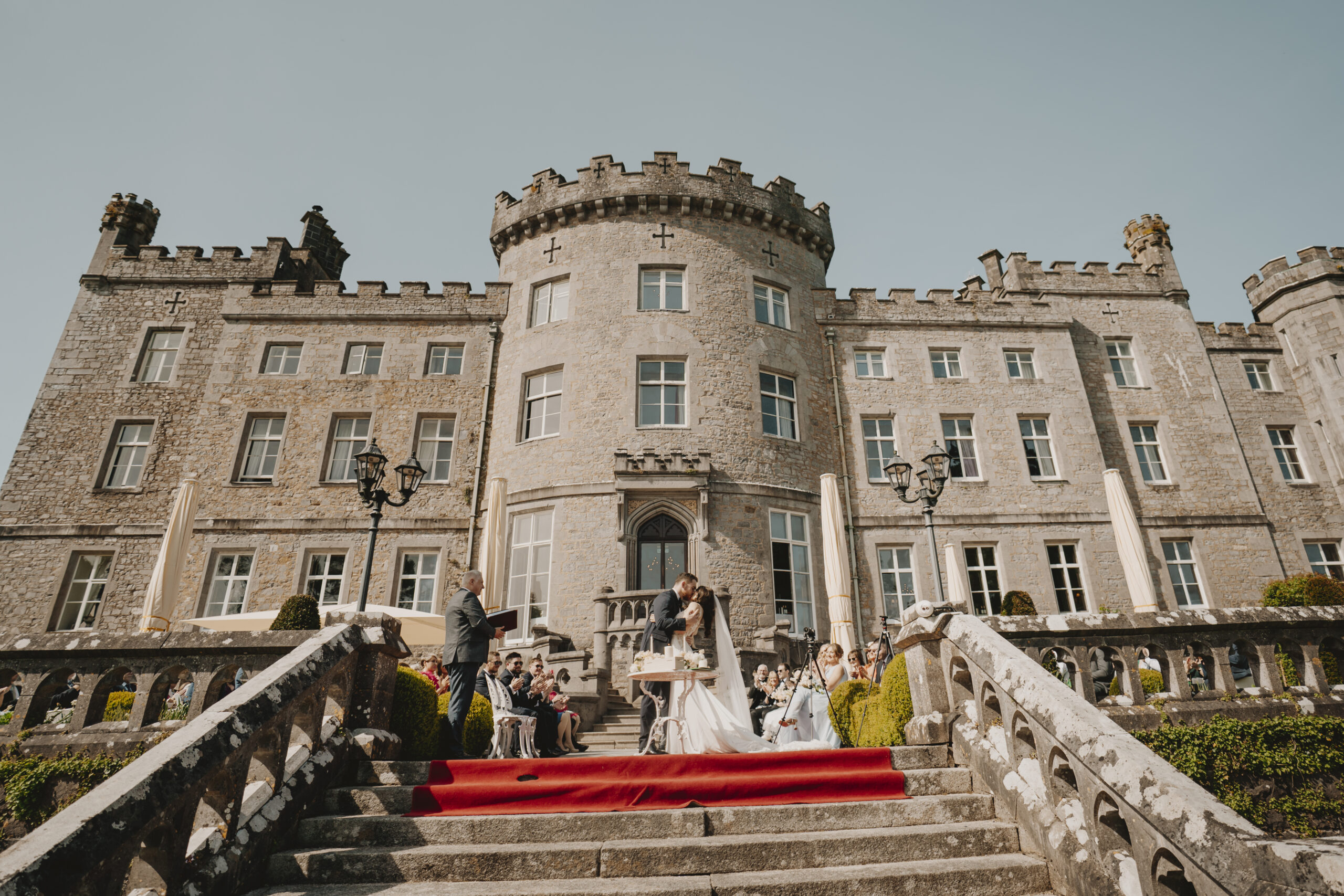 Bride and groom kissing during an outdoor summer wedding ceremony at Markree Castle