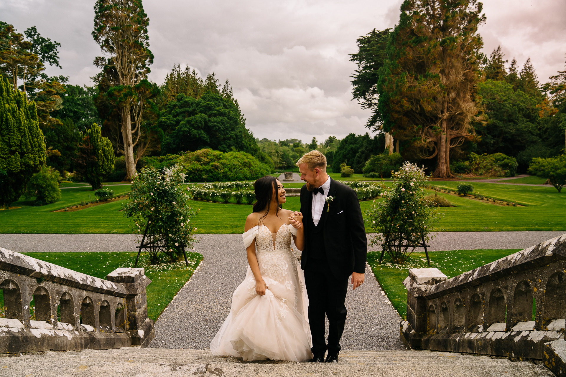 Bride and groom walking together in the formal gardens of Markree Castle during their elegant wedding in Sligo, Ireland