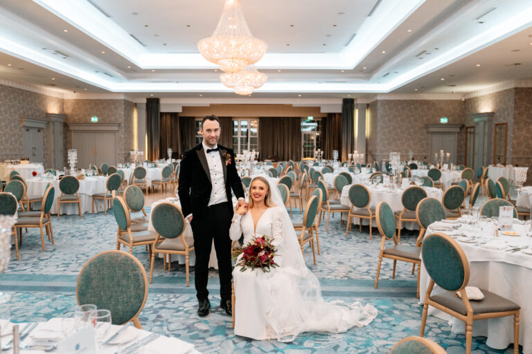 A bride and groom posing for a portrait inside the elegant wedding reception room at Slieve Russell Hotel.