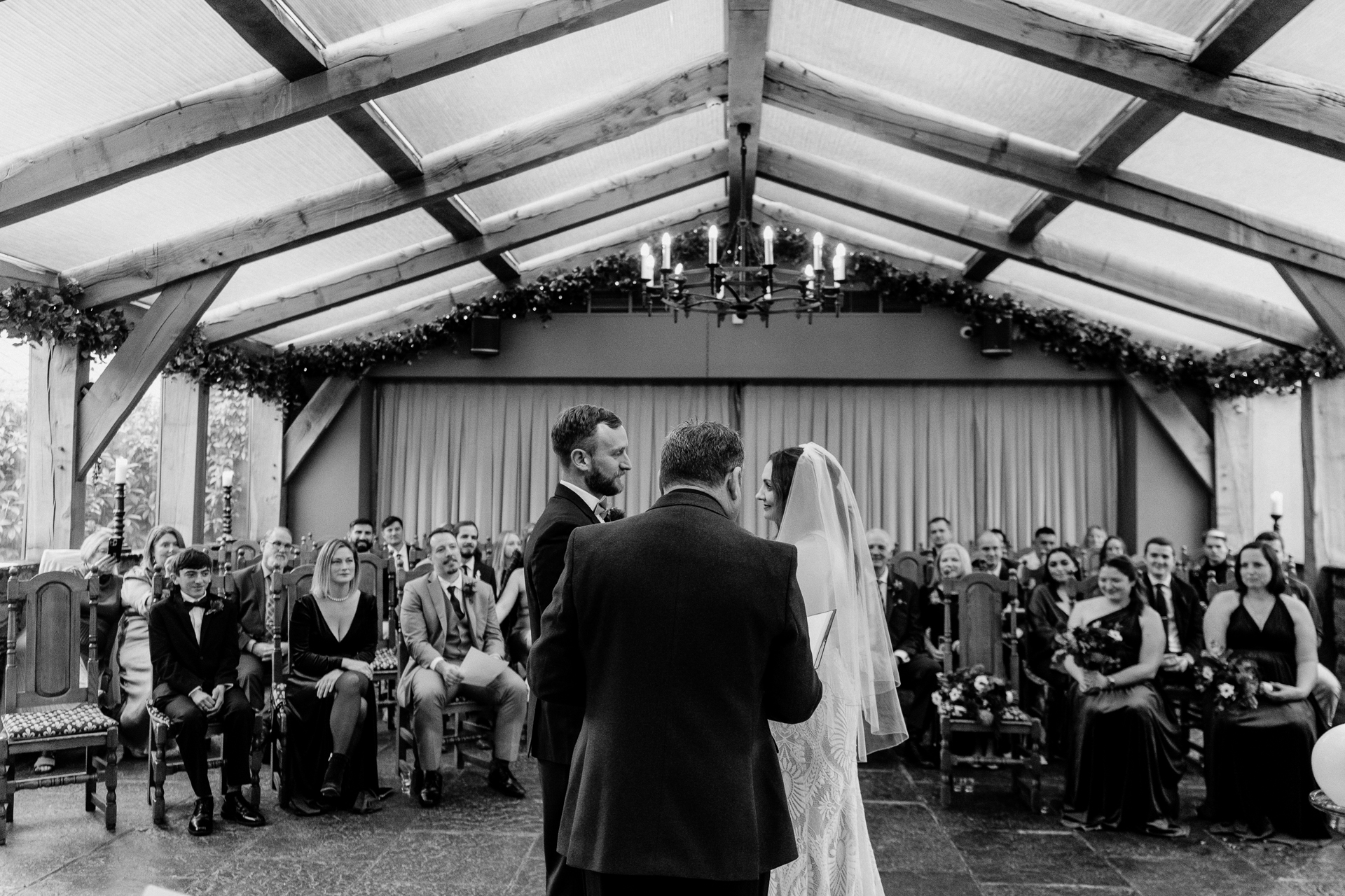A bride and groom walking down the aisle together inside the orangery at Barberstown Castle, as guests look on – photographed by a Dublin Wedding Photographer.