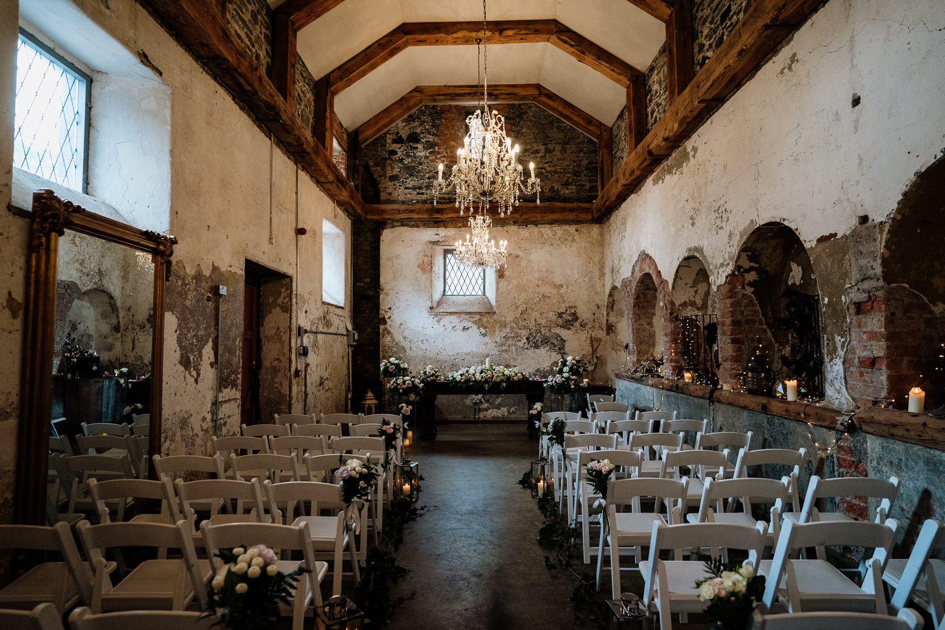 Ceremony space at Belleek Castle with floral arrangements and chandeliers