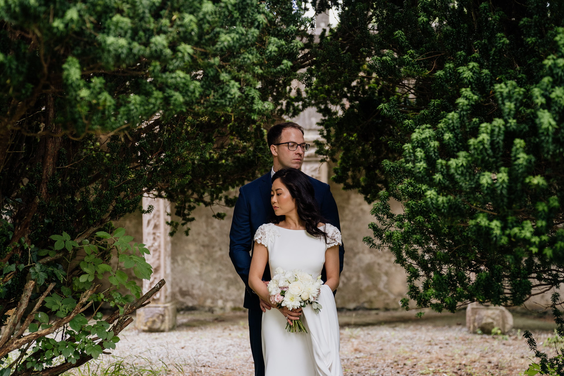 Bride leaning back into groom’s arms under a tree near Belleek Castle