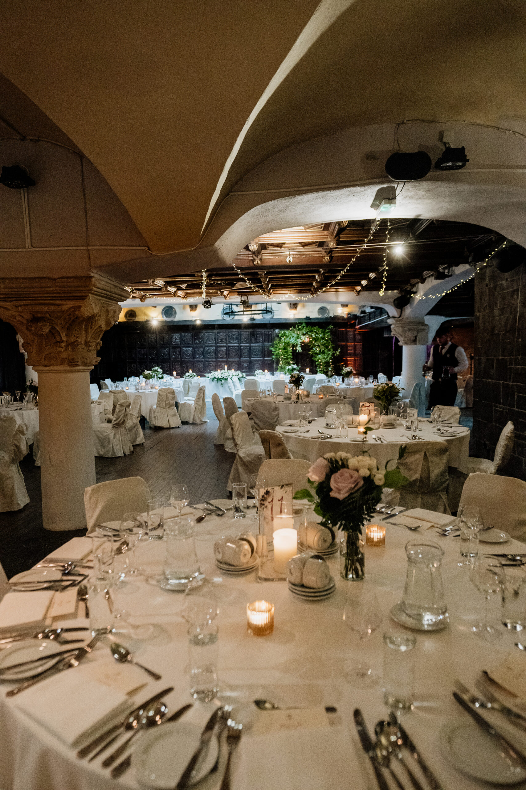 Wedding reception room setup with round tables and candlelight at Belleek Castle