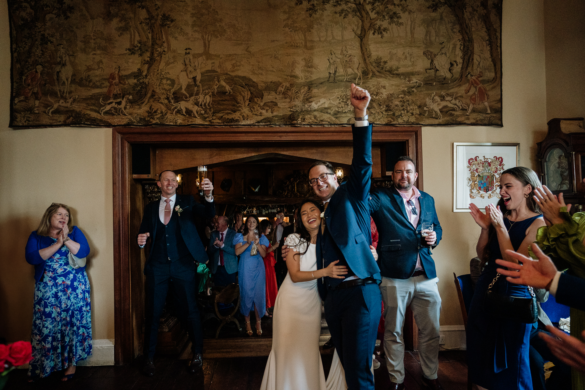 Bride and groom raising their arms and smiling during the wedding celebration