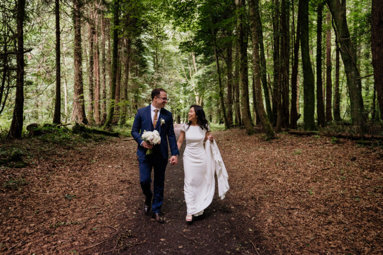 Bride and groom walking hand in hand through the forest at Belleek Castle – captured by a Belleek Castle Wedding Photographer