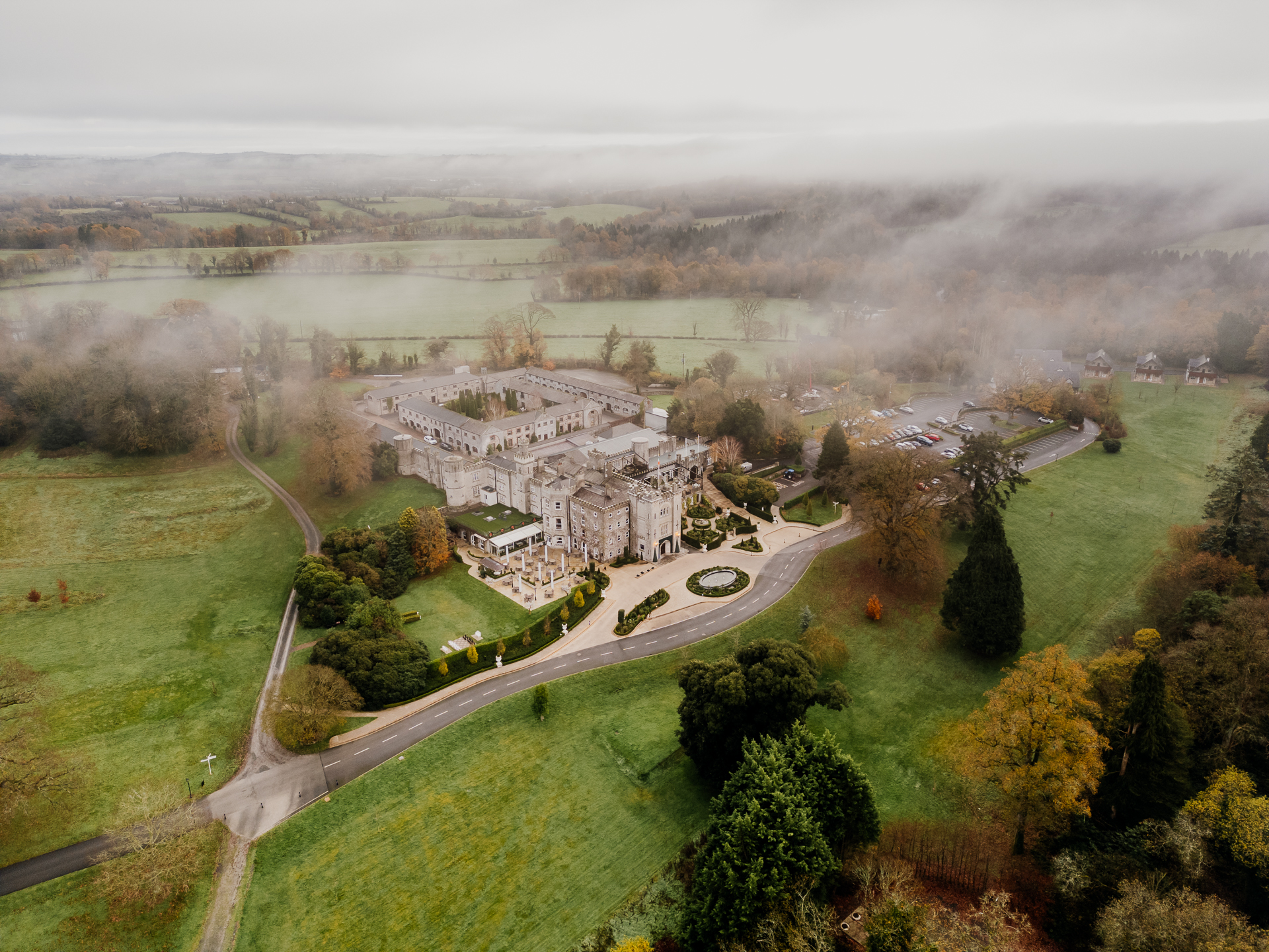 Aerial view of Cabra Castle in Ireland surrounded by mist and countryside