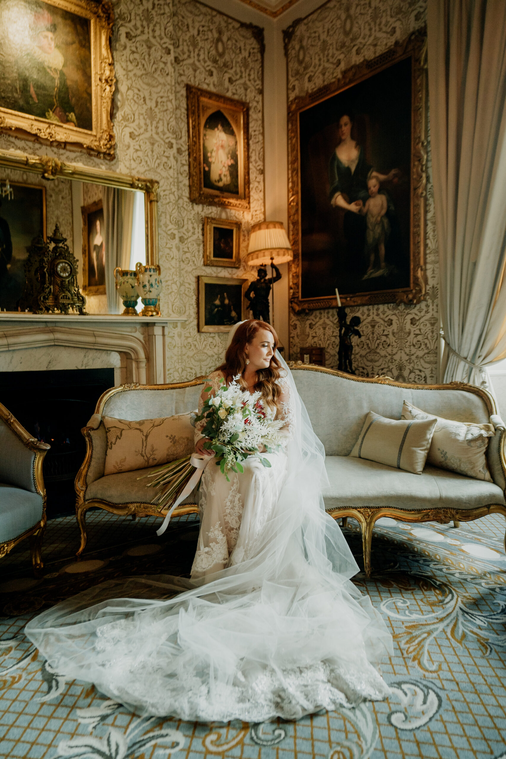 Bride sitting alone in the golden suite at Cabra Castle, wearing a wedding dress with a long train.