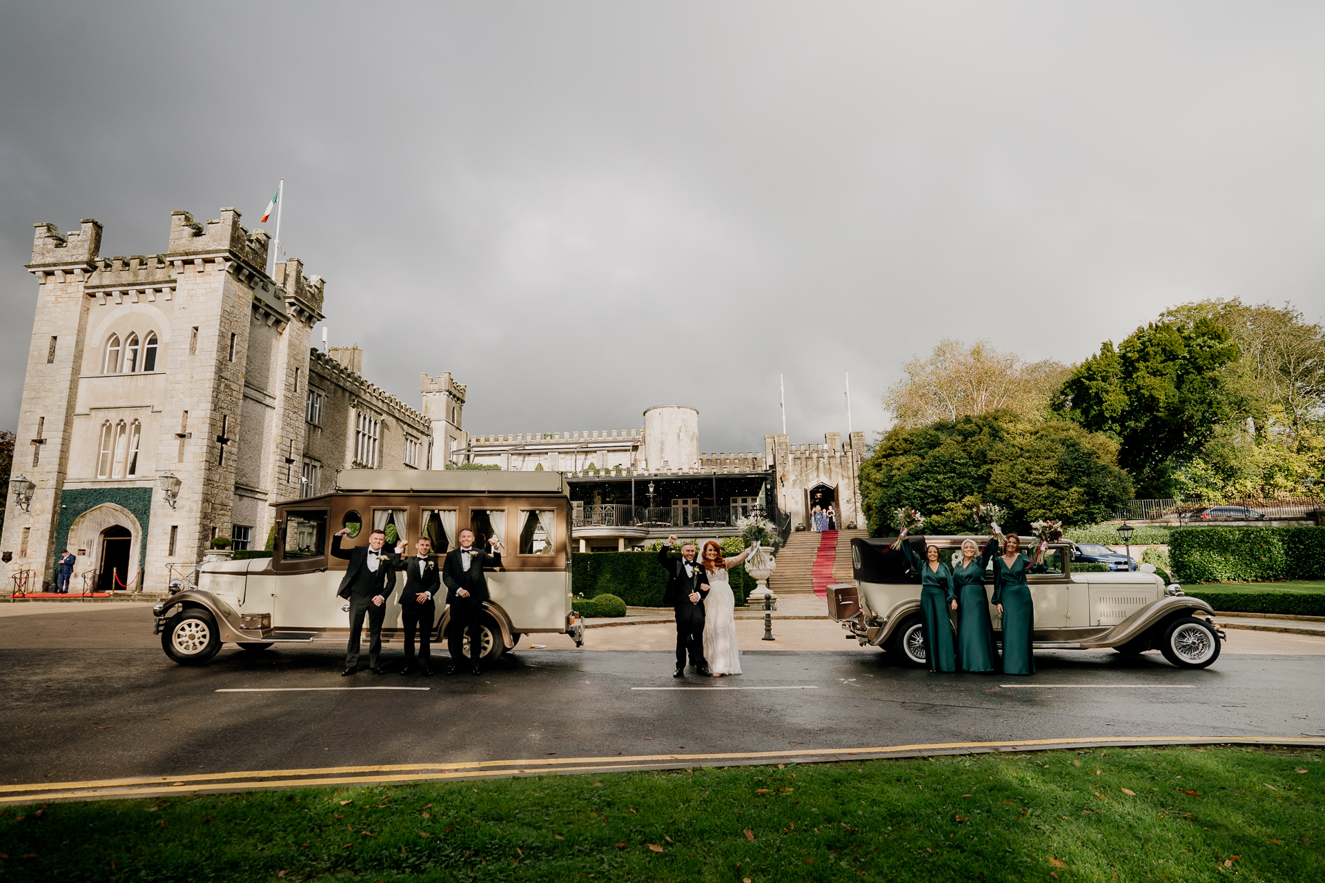 Bride, groom, and guests arriving at Cabra Castle with vintage cars and laughter.