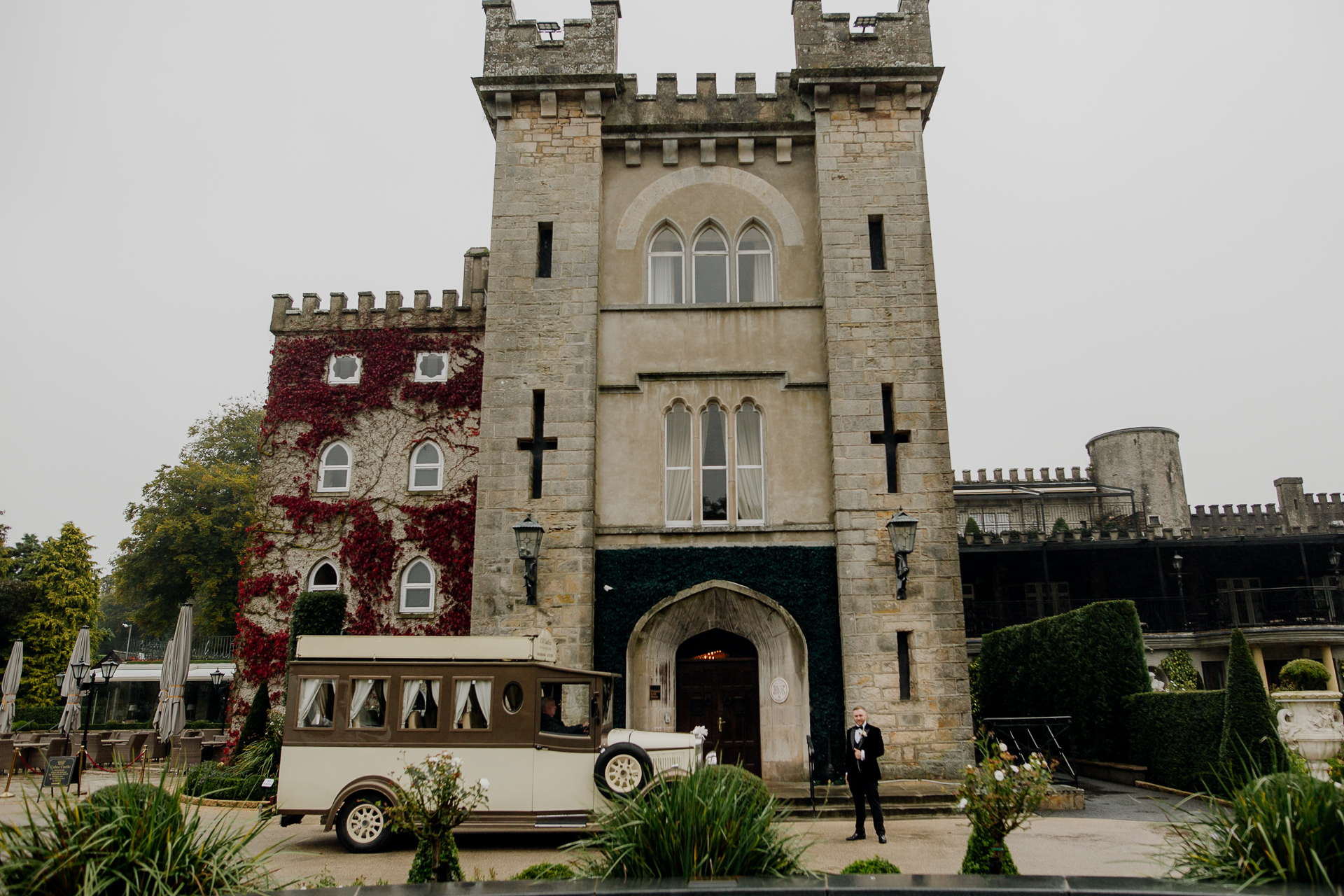 Vintage car parked in front of Cabra Castle on a wedding day