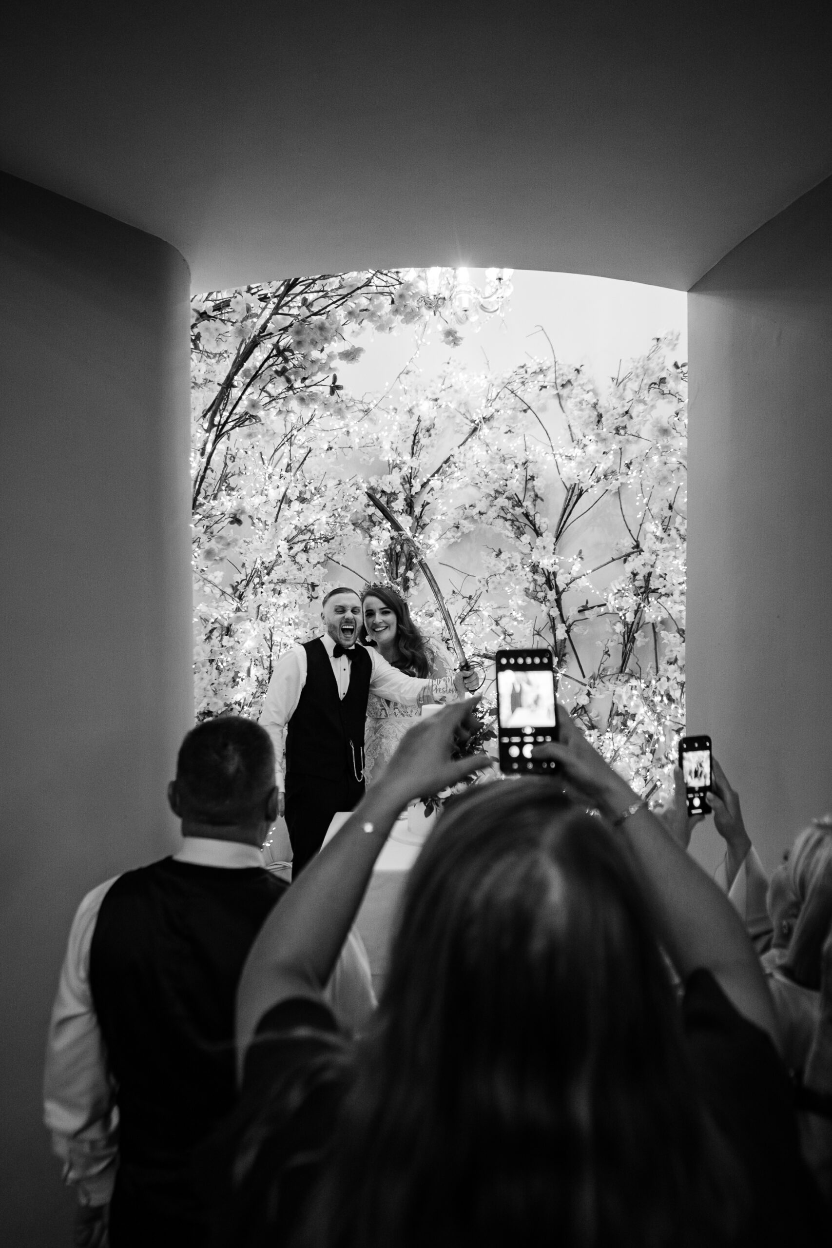 Wedding couple surrounded by guests during celebration at Cabra Castle cake area