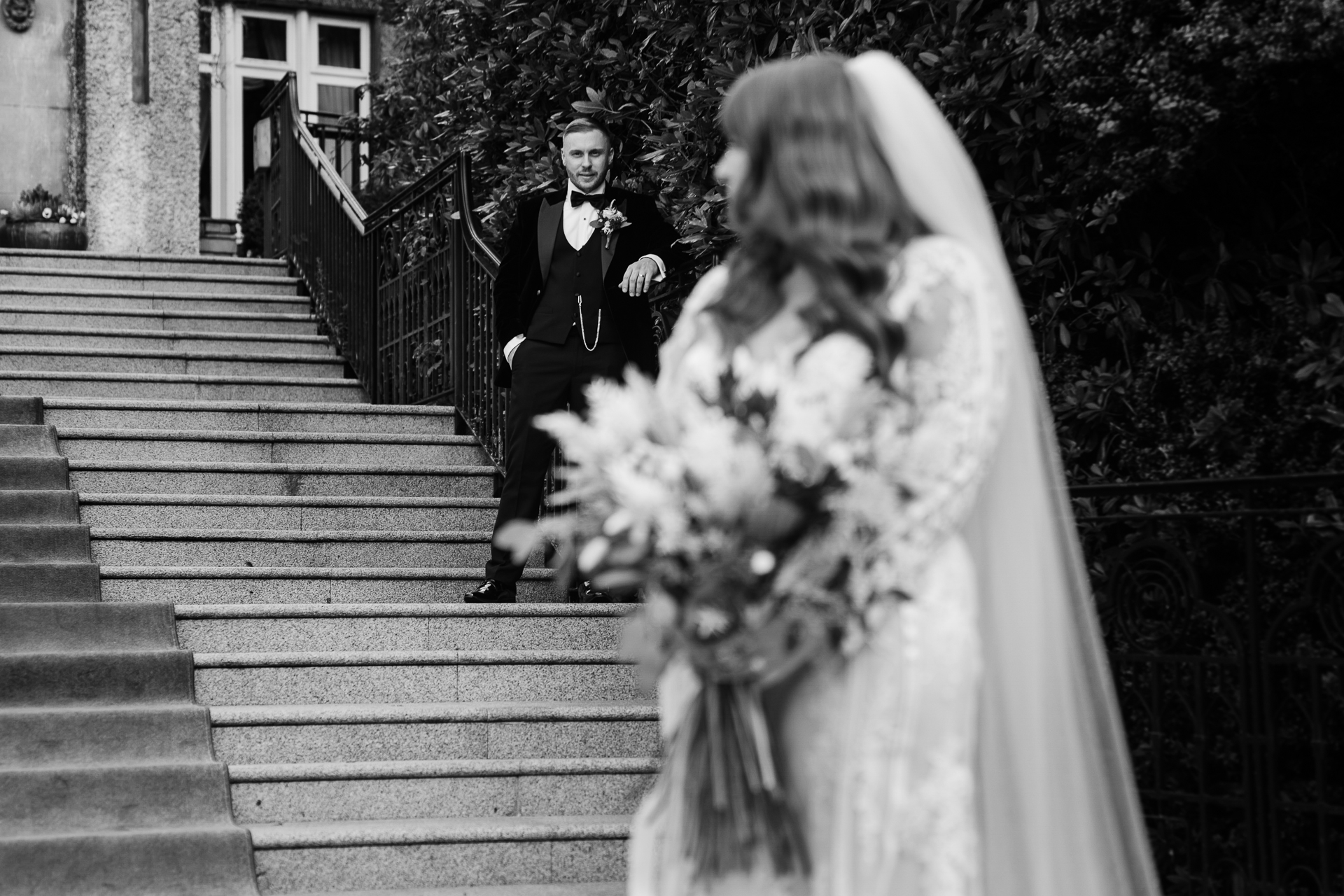 Father walking his daughter, the bride, down the stone steps before the ceremony at Cabra Castle – black and white photo