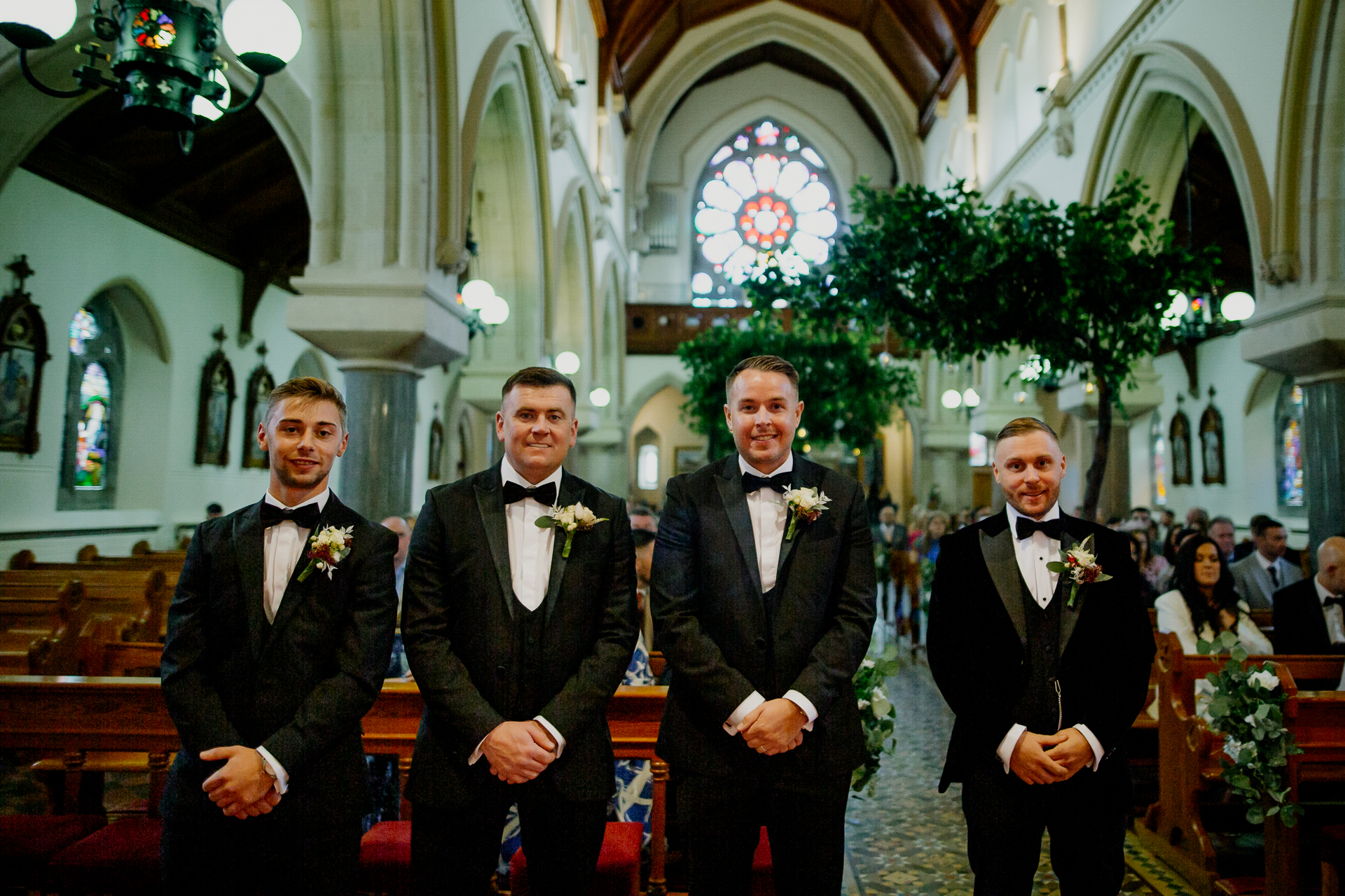 Groom and groomsmen standing inside a church before the ceremony at Cabra Castle