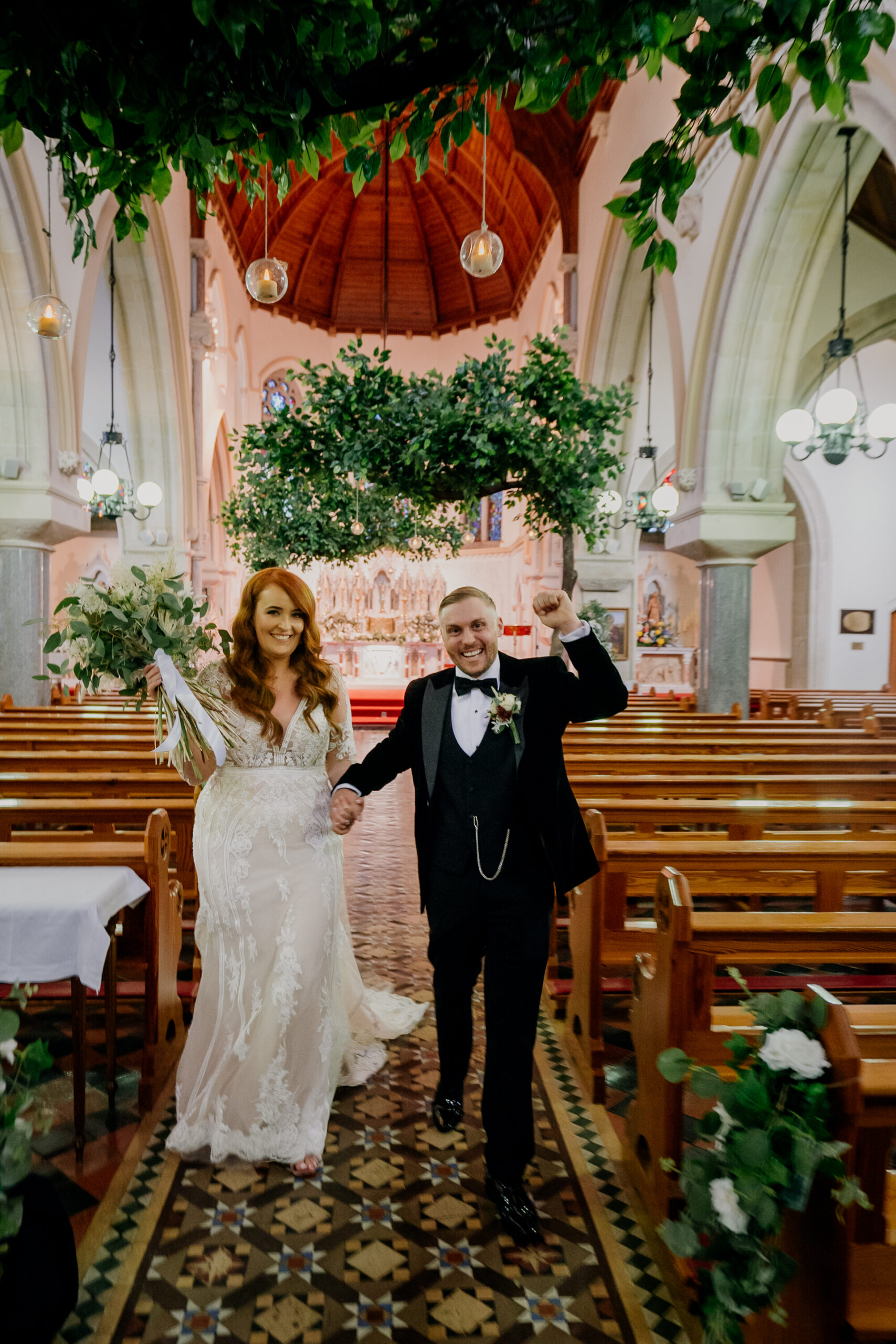 Just married bride and groom walking down the aisle in the church at Cabra Castle Wedding