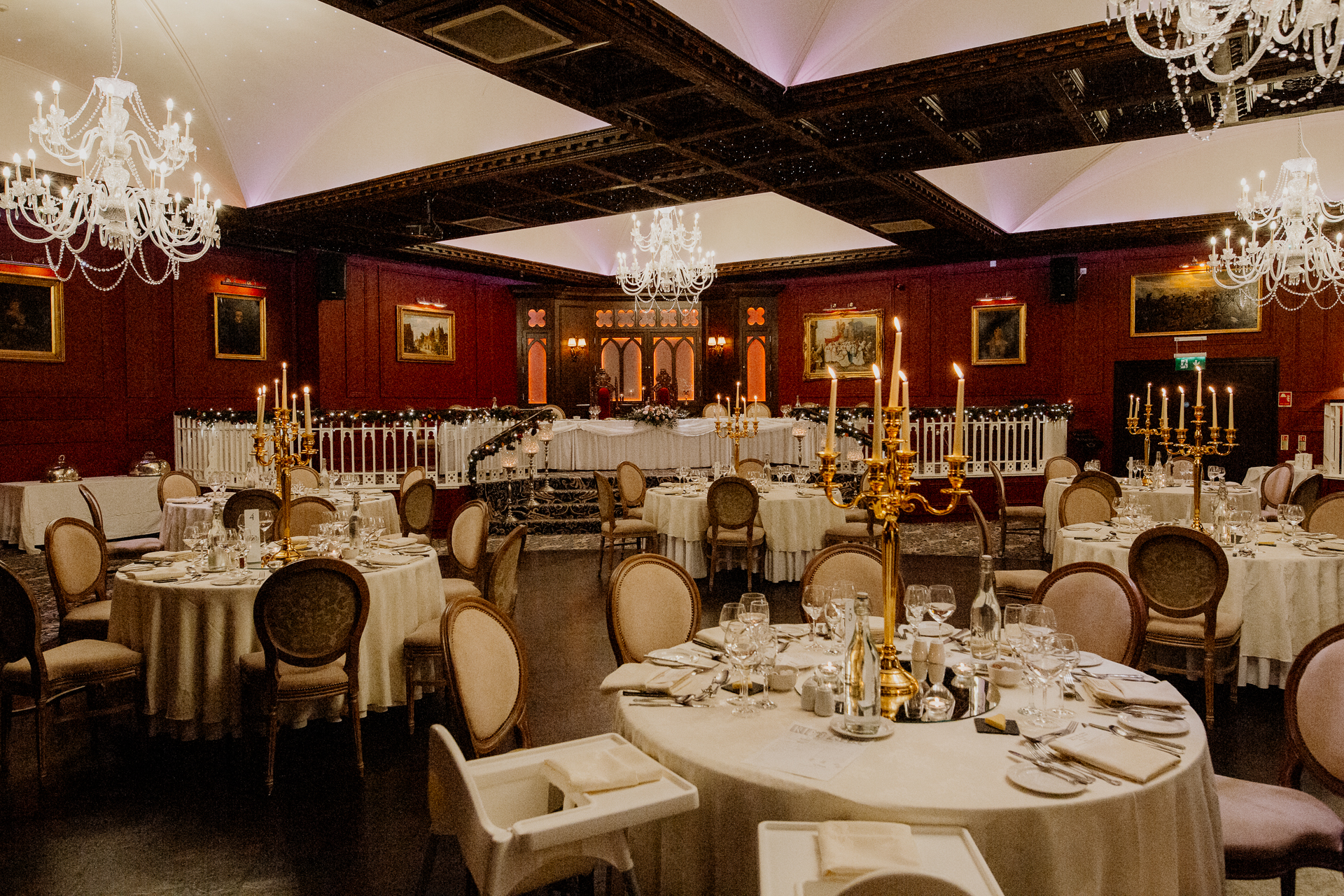Cabra Castle wedding reception room with elegant chandeliers and round tables.
