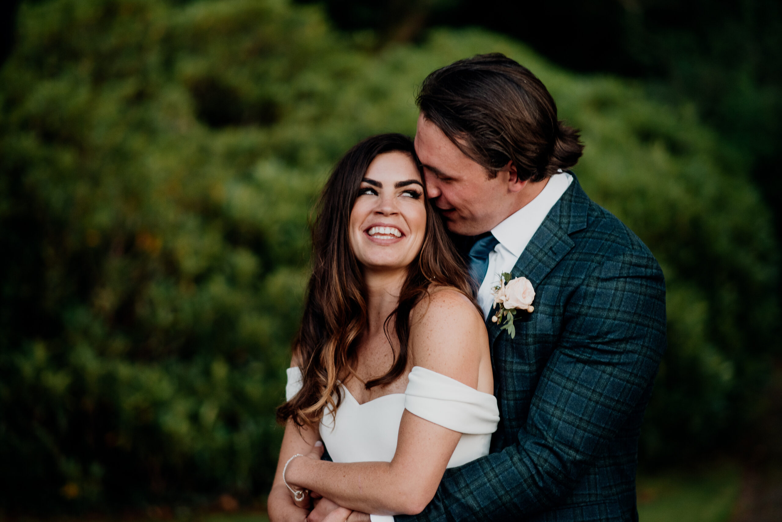 Bride and groom laughing under trees during their Markree Castle wedding in Ireland – a romantic candid moment from a destination celebration