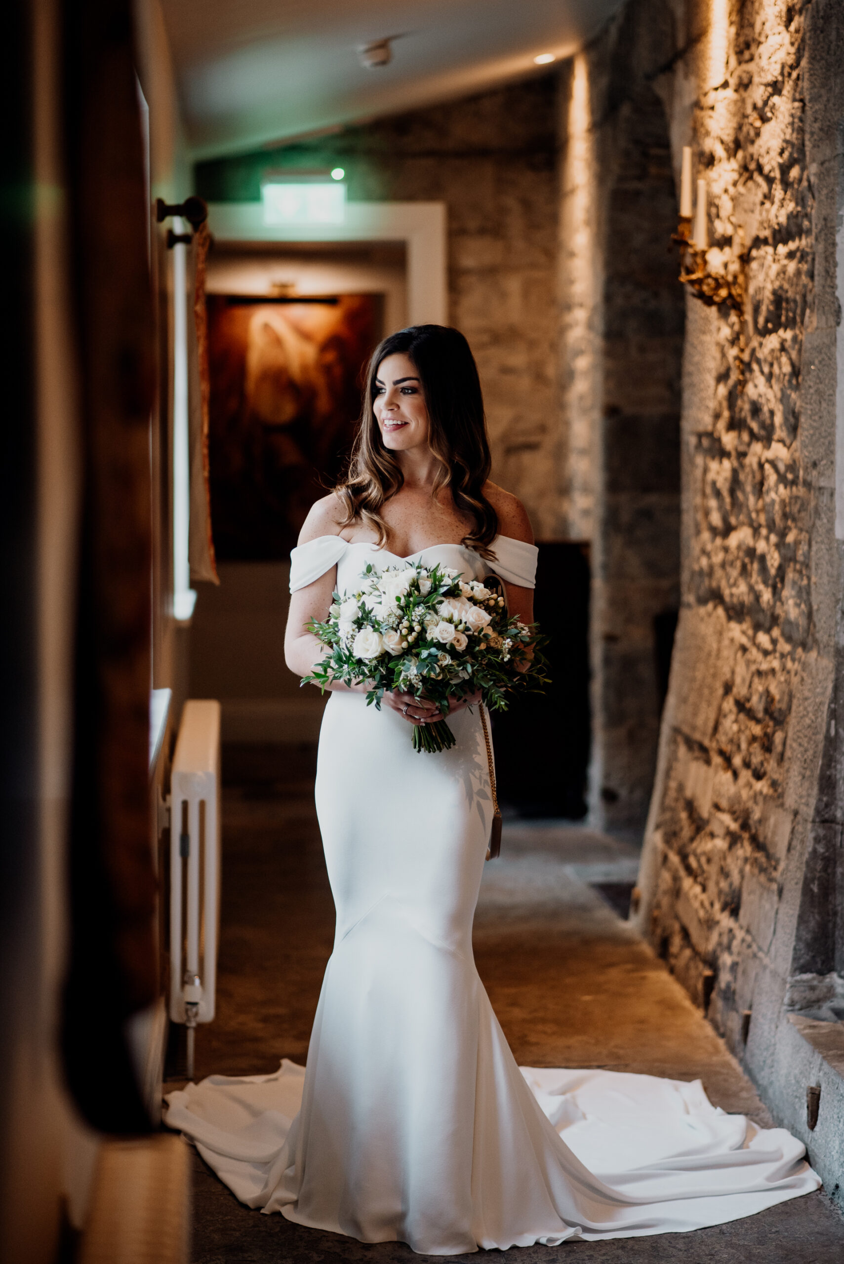 Bride walking through stone hallway at Markree Castle – destination wedding in Ireland