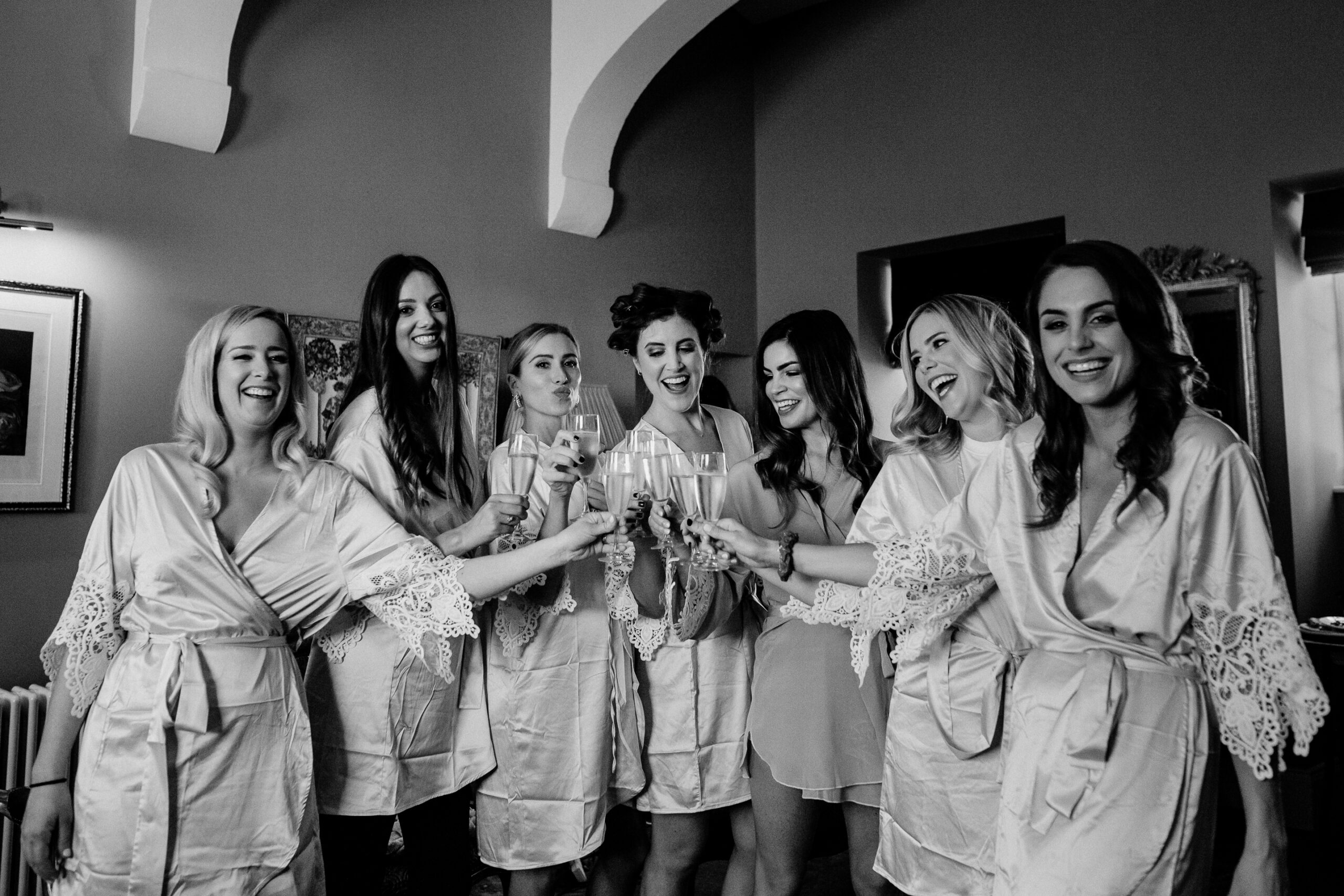 Bridesmaids in robes toasting together in Markree Castle bridal suite – fun wedding morning moment in Ireland