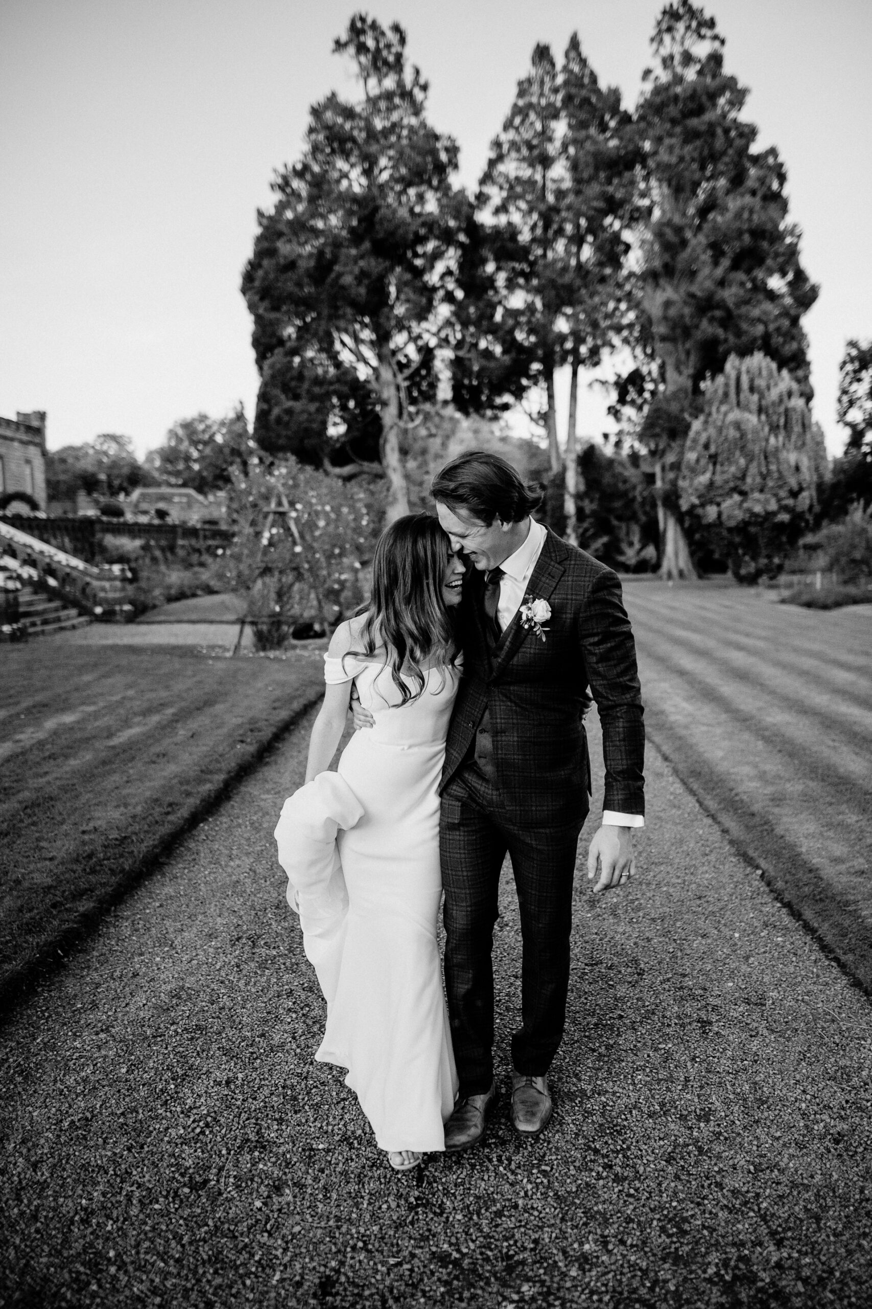 Bride and groom kissing during a romantic walk along the driveway of Markree Castle – candid destination wedding photo in Ireland