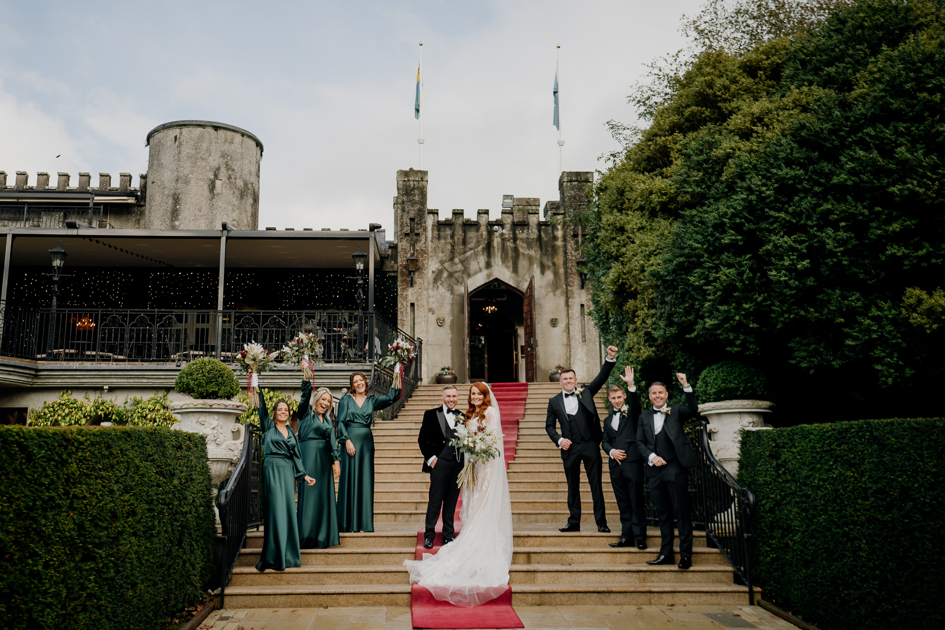 Bride and groom arriving at Cabra Castle, greeted by guests on the stone staircase – Dublin Wedding Photographer