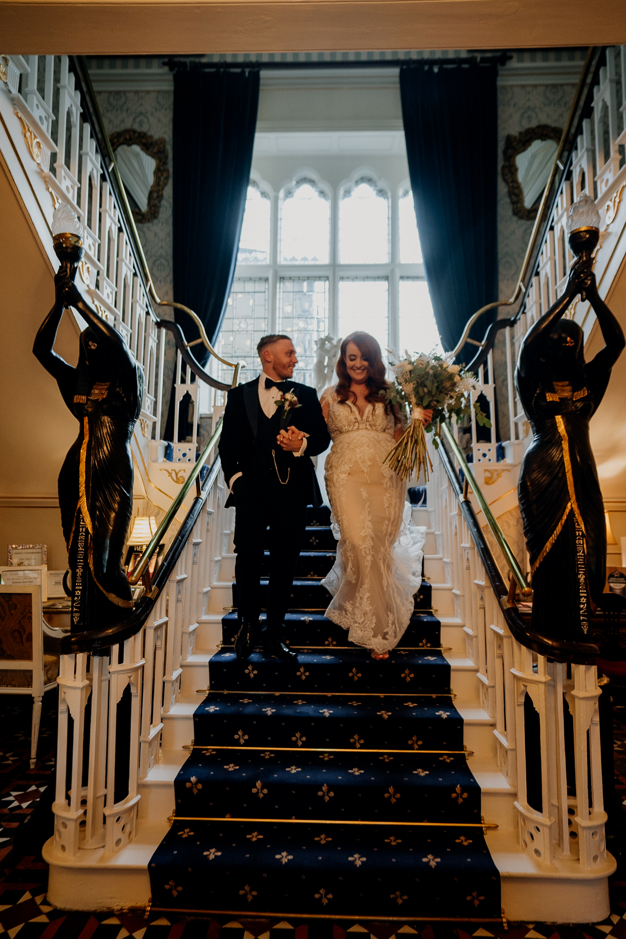 Bride and groom walking down the grand staircase at Cabra Castle – Cabra Castle Wedding Photographer