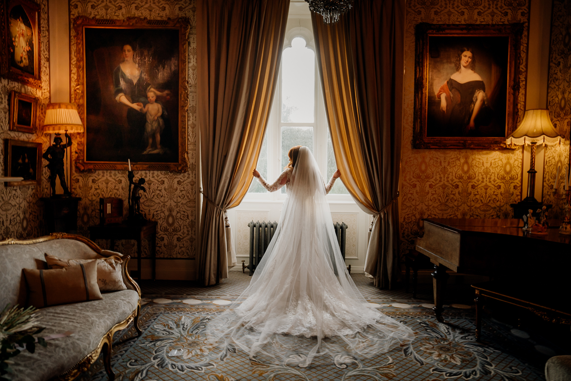 Bride standing in front of large window in a luxury castle bridal suite near Dublin – Dublin Wedding Photographer