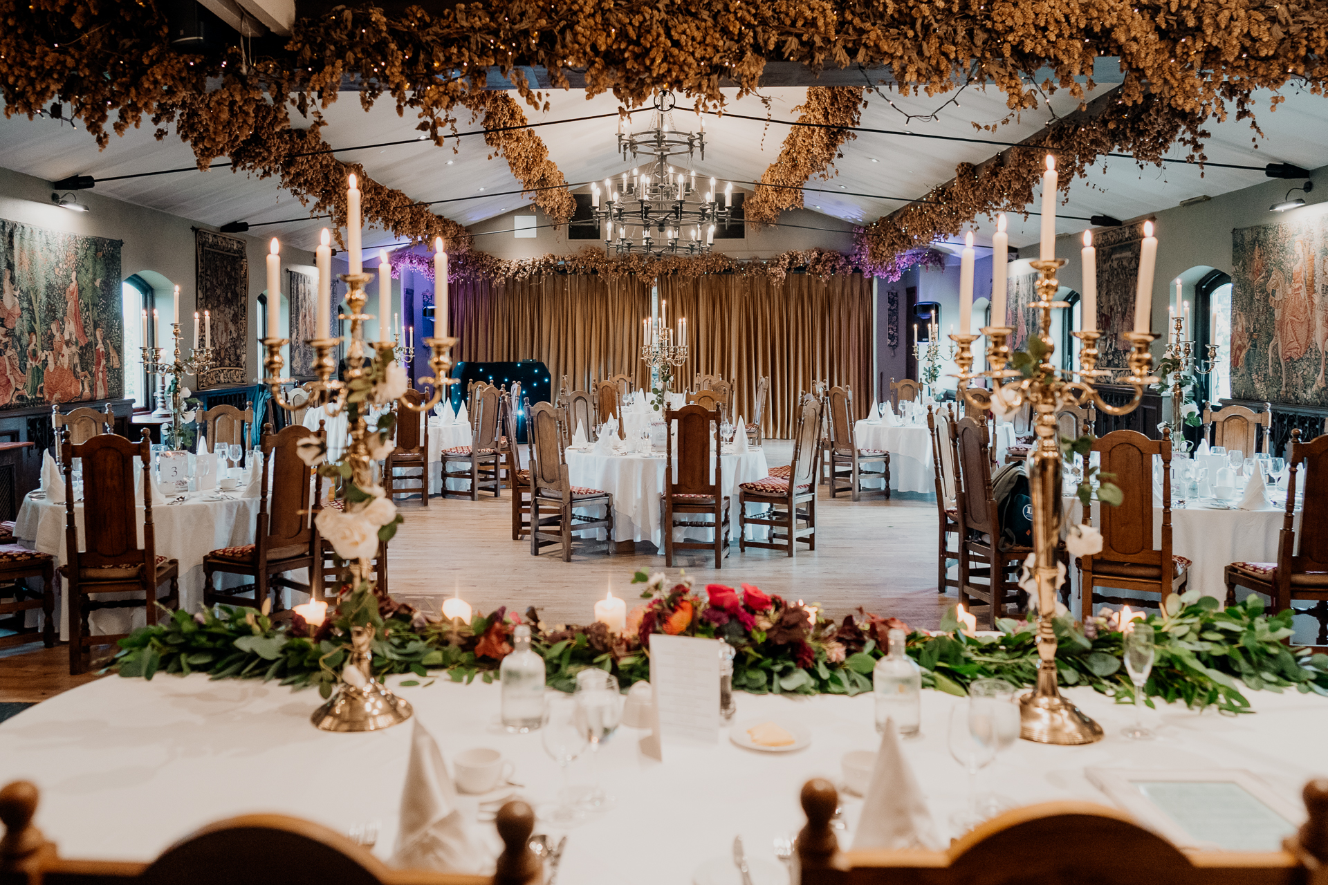 Elegant wedding reception setup with gold candle holders and floral table decorations in a luxury Dublin venue – Dublin Wedding Photographer
