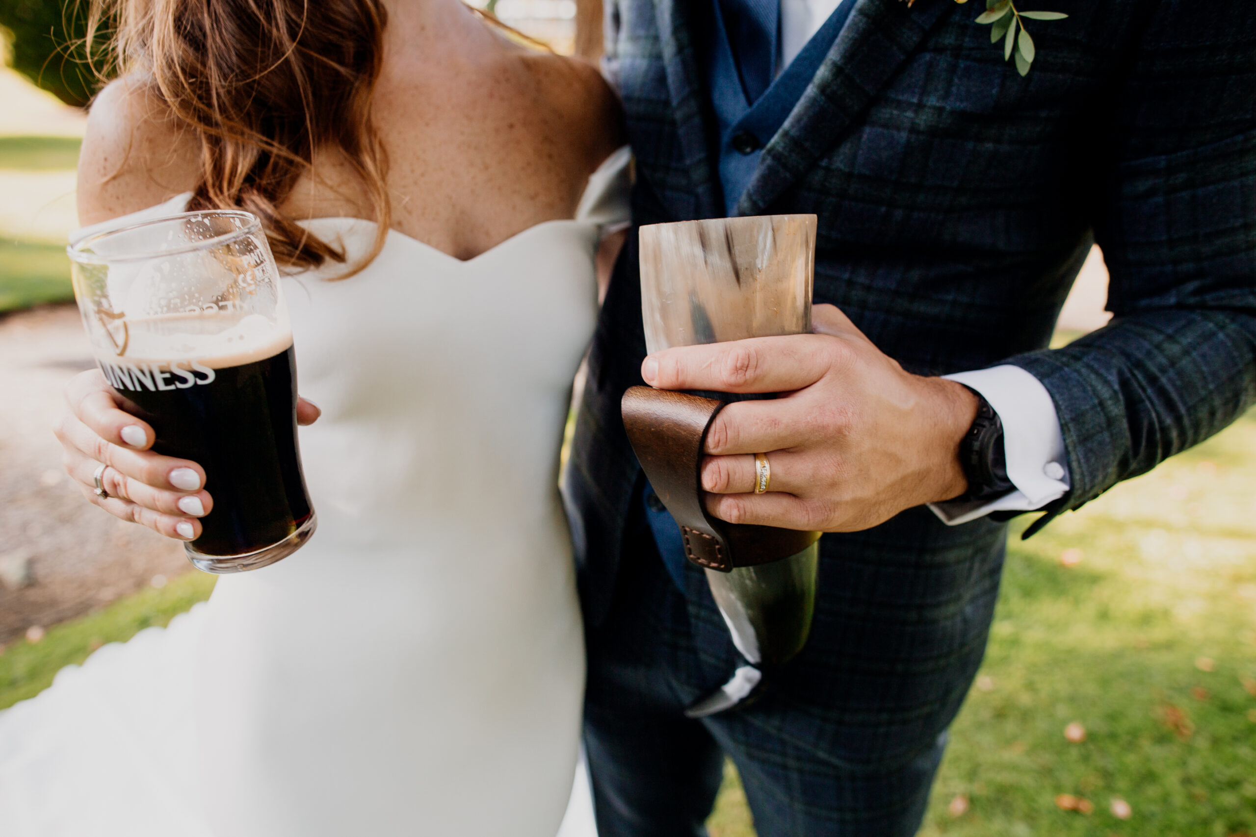 Bride and groom holding pints of Guinness during their drinks reception at an Irish castle wedding