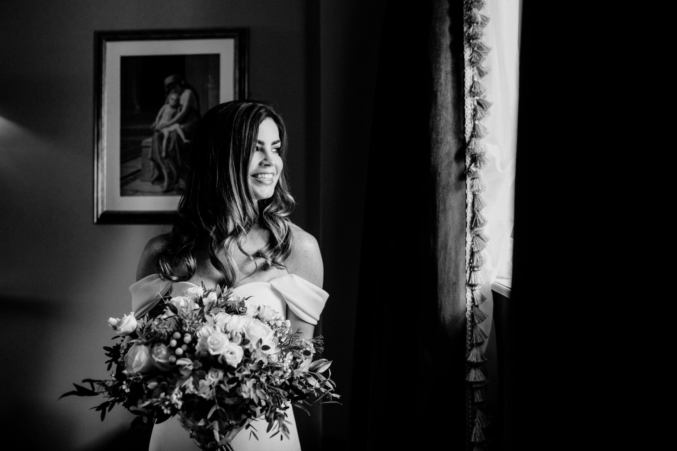 Bride holding her bouquet in soft window light – black and white bridal portrait at Markree Castle suite.