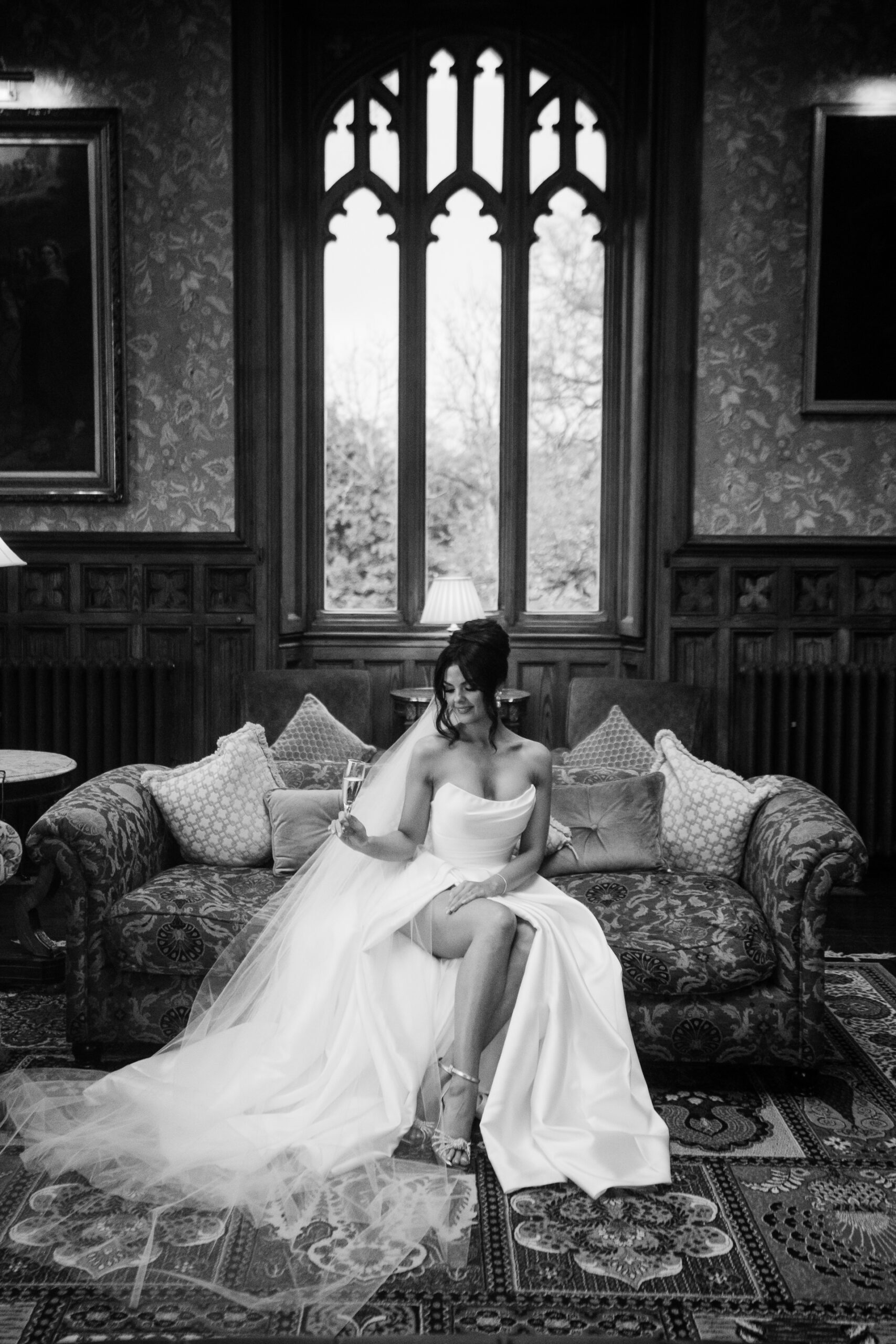 Black and white bridal portrait at Markree Castle, bride sitting on vintage sofa in the Billiard Room