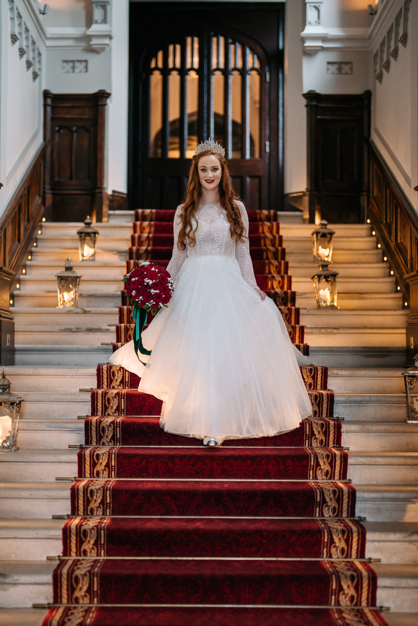 Bride standing on the grand red carpet staircase inside Markree Castle