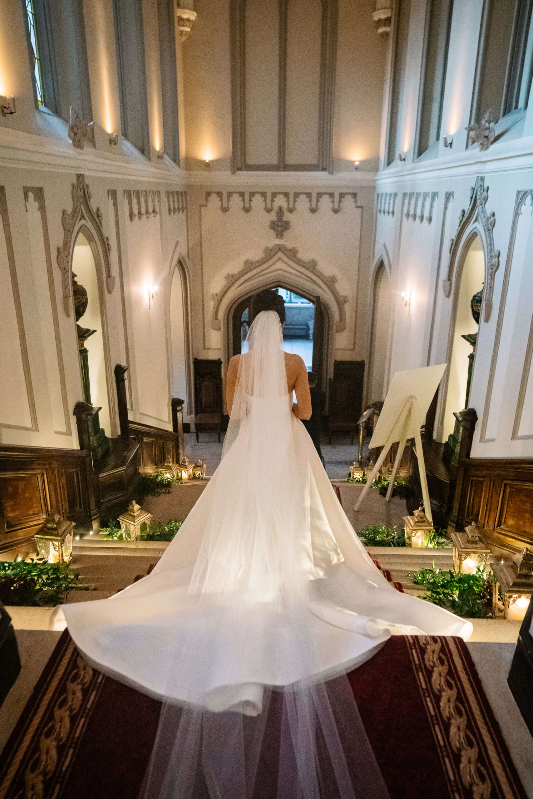 Bride in a long veil standing on the grand staircase inside Markree Castle