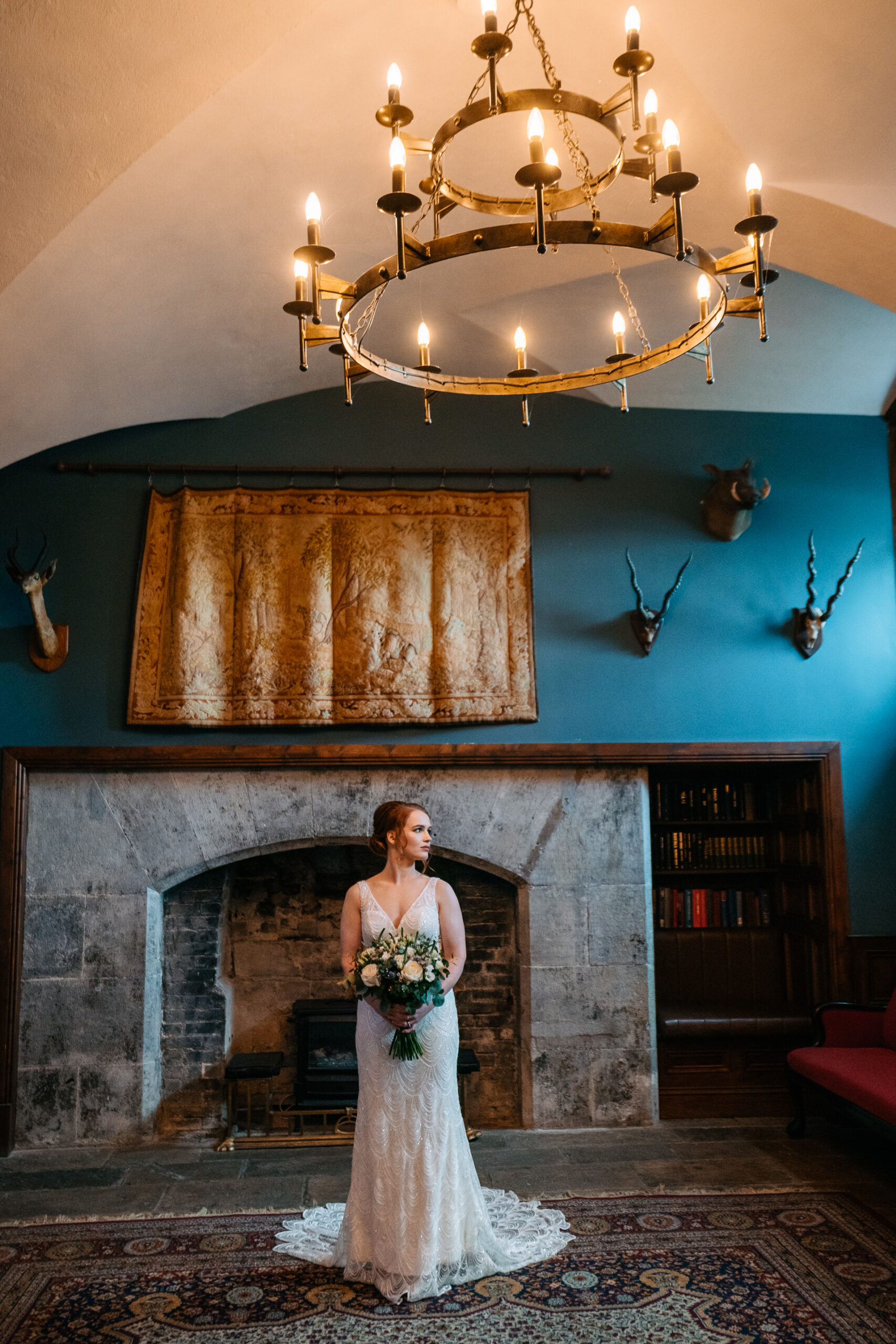 Elegant bride standing by a fireplace in the corridor next to the Gin Bar at Markree Castle