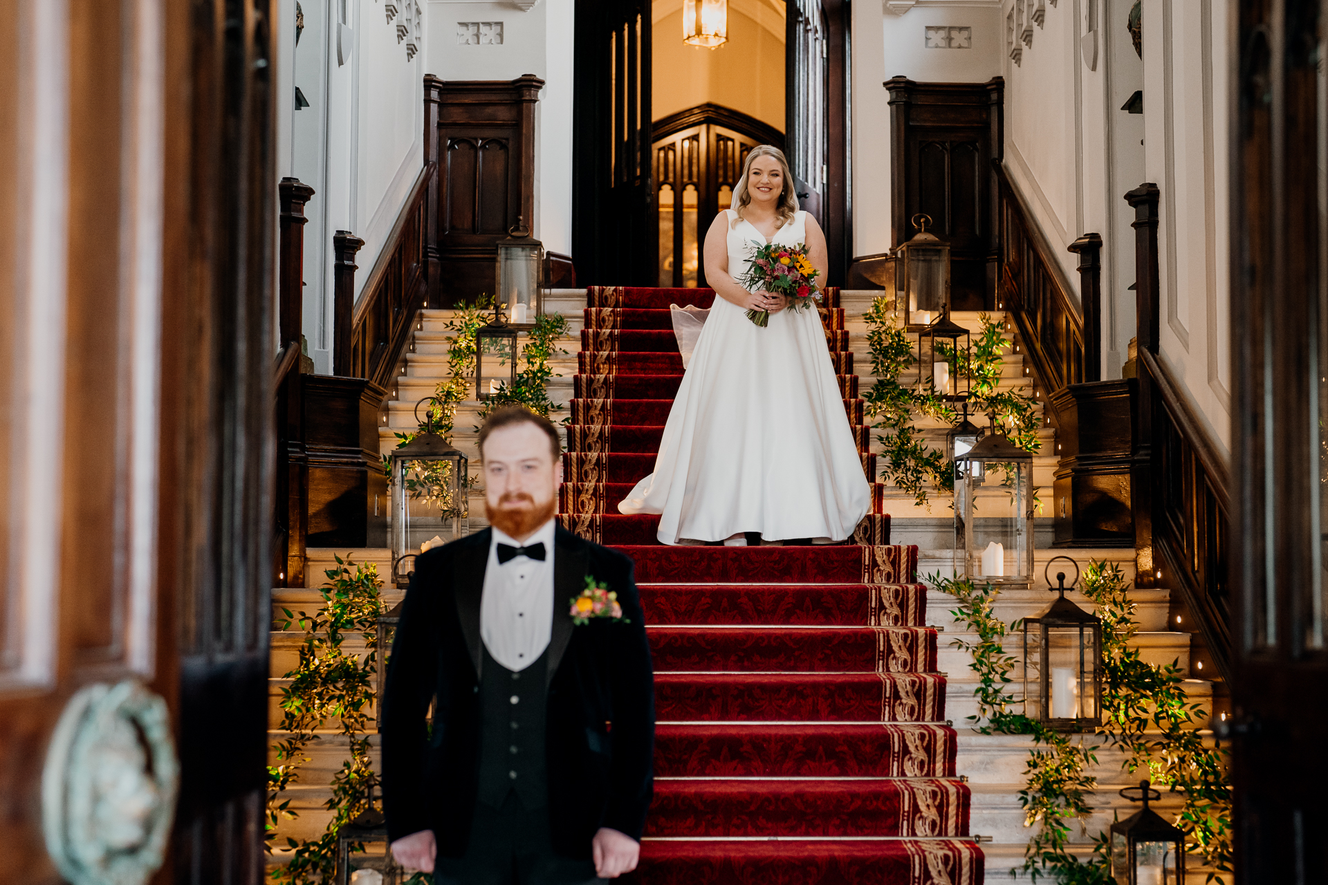 Bride walking down the red-carpeted grand staircase for a First Look at Markree Castle wedding