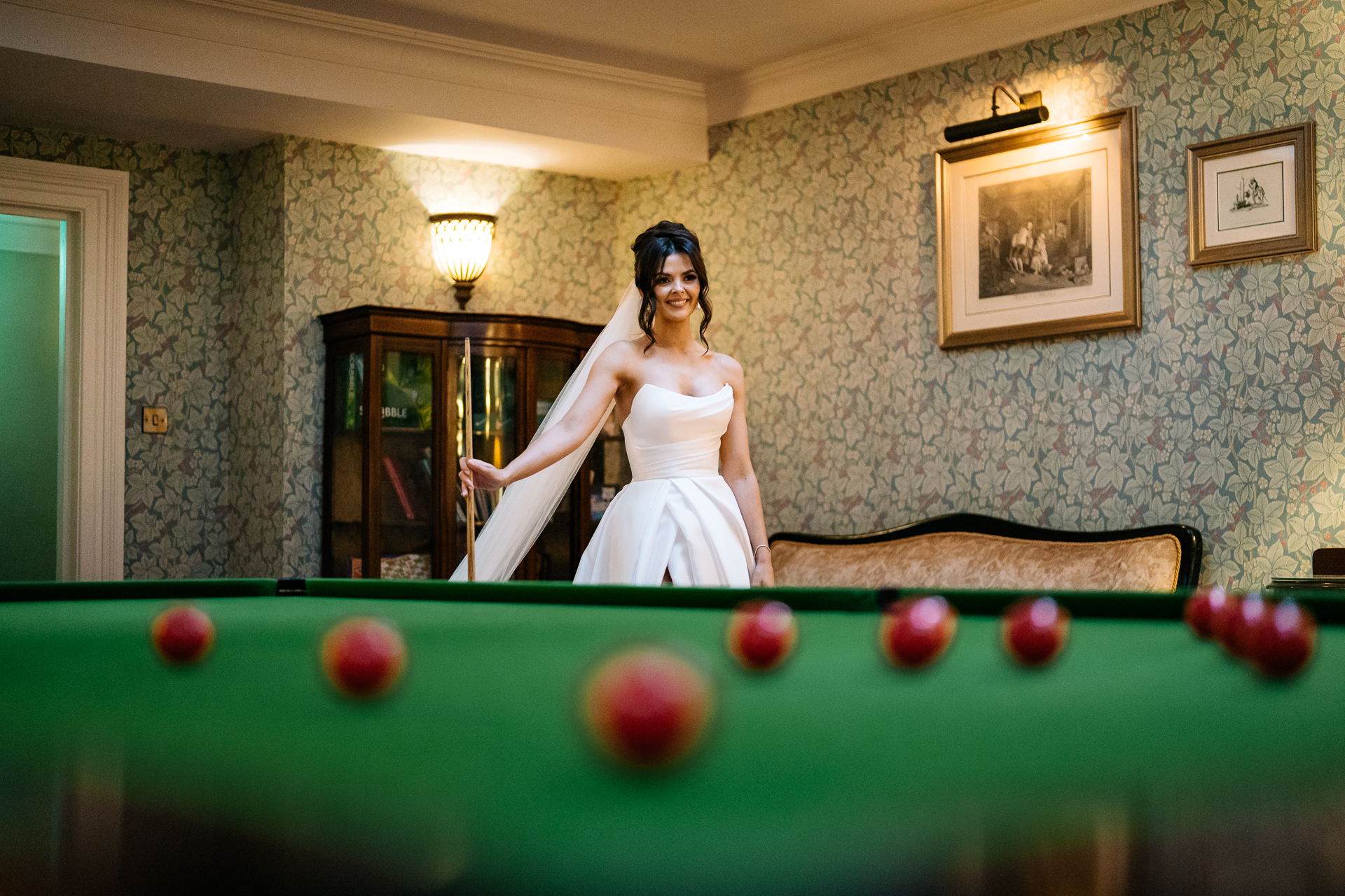 Bride posing beside a snooker table in the Snooker Room of Markree Castle