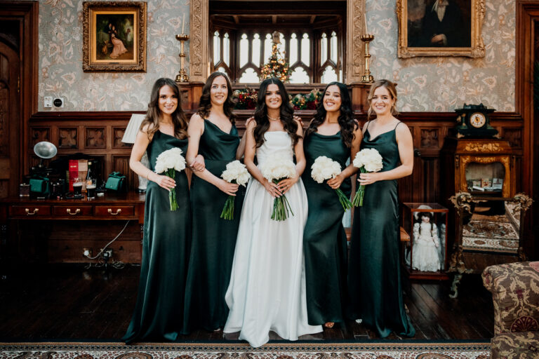 Bridal party group portrait in green dresses at Markree Castle wedding, captured in the classic wooden interior.